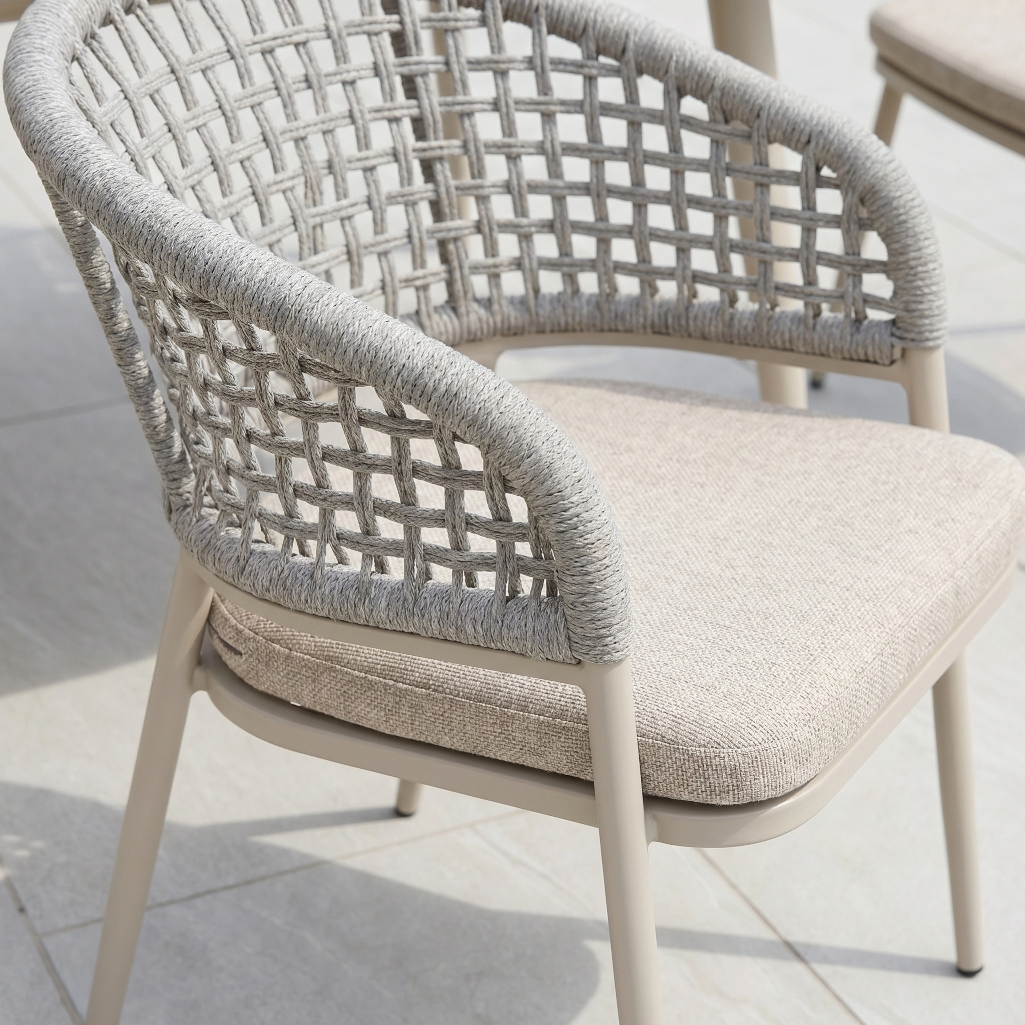 Contemporary outdoor chair with a woven rope backrest and beige cushion, designed to perfectly match the Kalama 8 Seat Oval Rope Dining Set in Oatmeal for your patio or balcony.