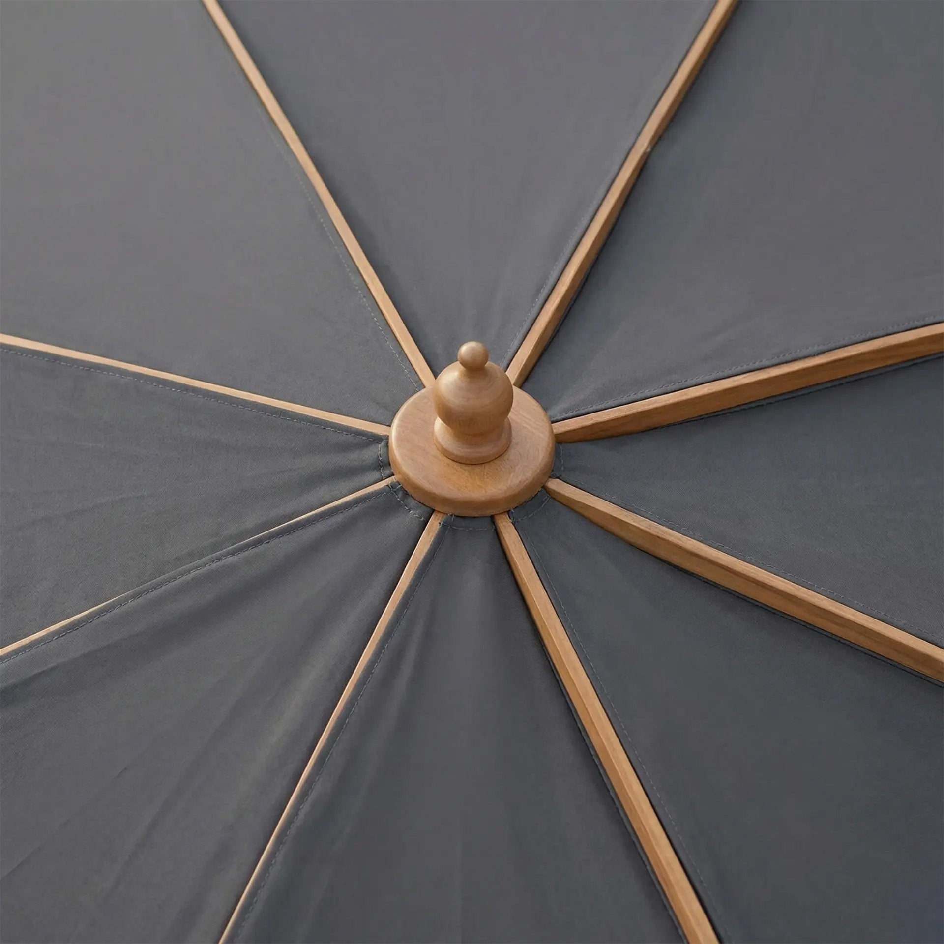 Close-up of the Kratos 3m x 2m Rectangular Wooden Parasol in Grey, featuring wooden spokes and a central finial, highlighting its elegant design as an outdoor sun protector.