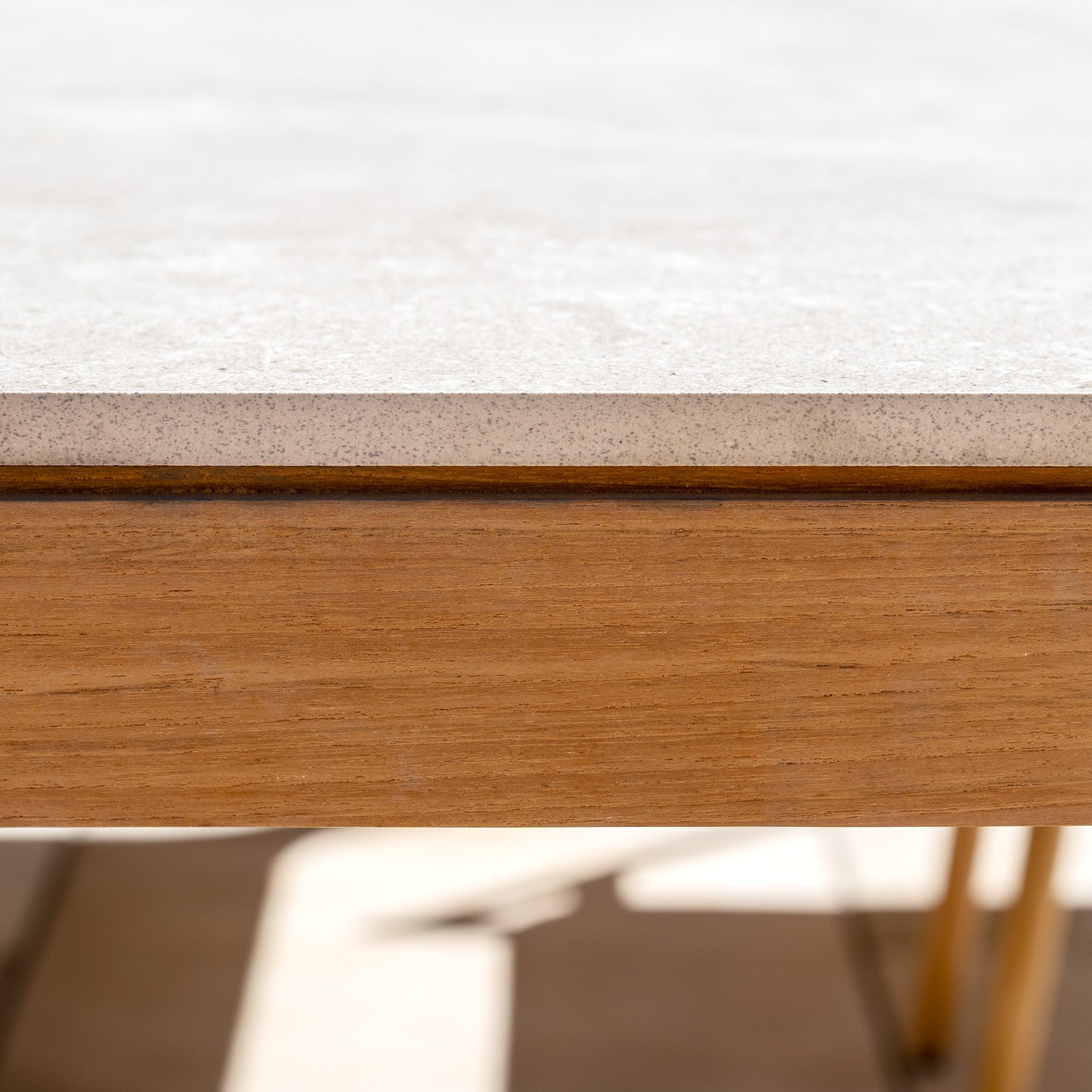 Close-up of the Lucca 8 Seat Dining Set with Ceramic Top Table in Natural Weave, featuring outdoor furniture with a light-colored ceramic tabletop and wooden edge against a sunlit background.