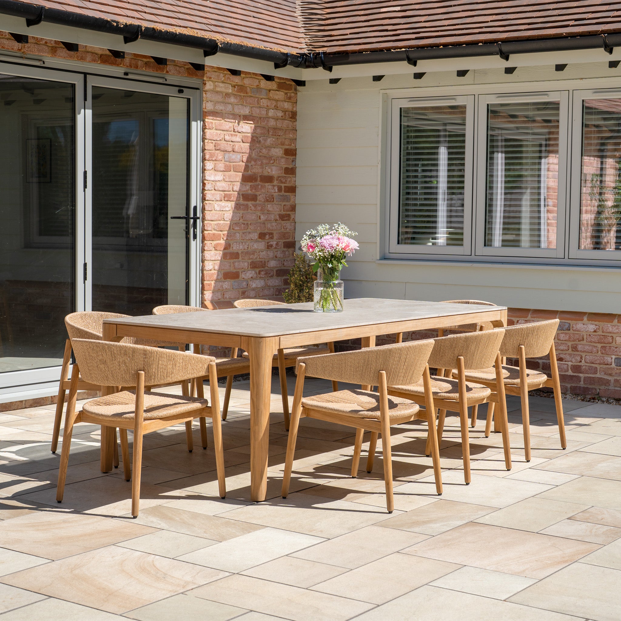 The Lucca 8 Seat Dining Set with Ceramic Top Table in Natural Weave includes eight chairs and a stylish ceramic-top table, ideal for enhancing your patio with elegant outdoor dining furniture.