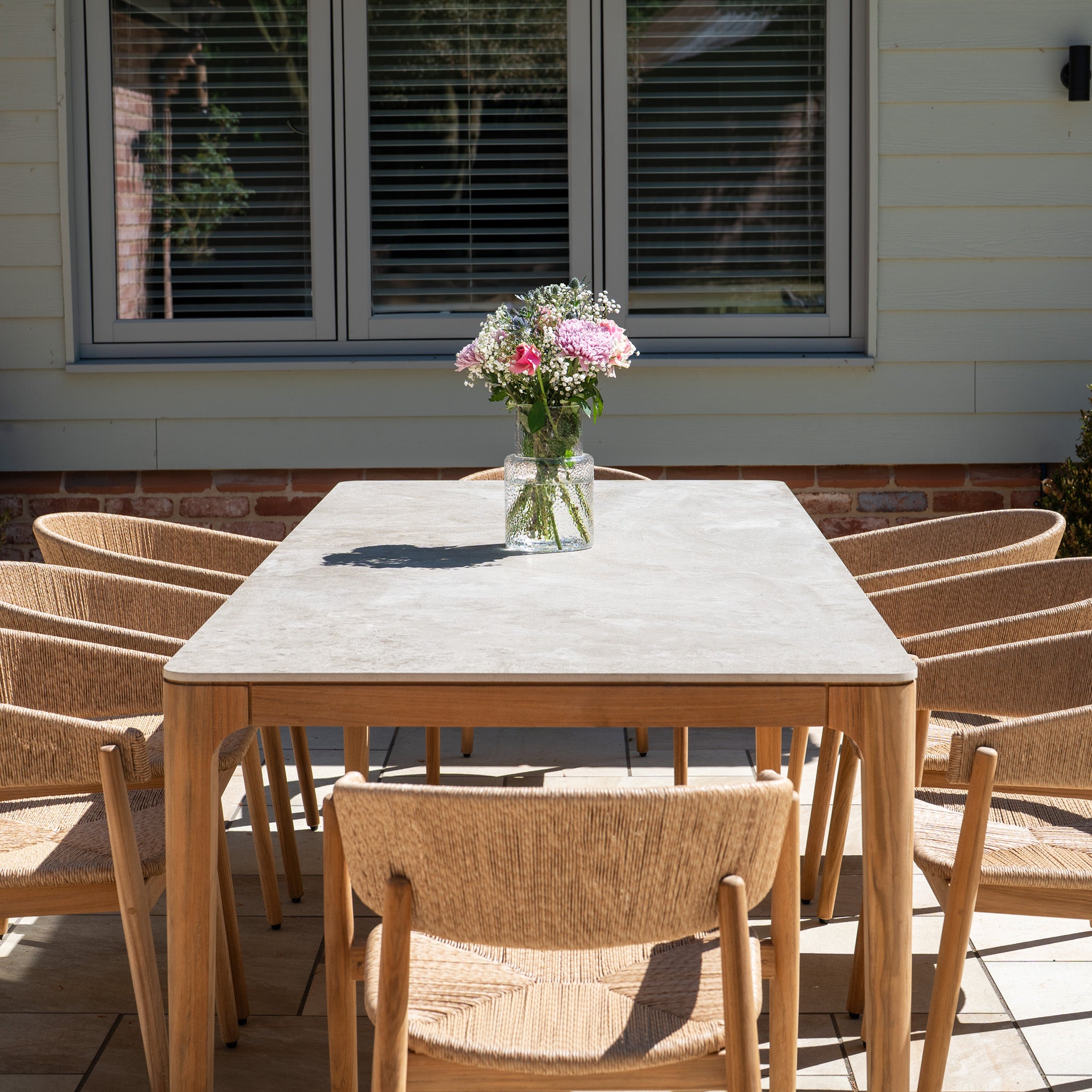 The Lucca 8 Seat Dining Set with Ceramic Top Table in Natural Weave includes a spacious ceramic-topped table and seating for eight, making it ideal for stylish outdoor dining on your sunny patio.