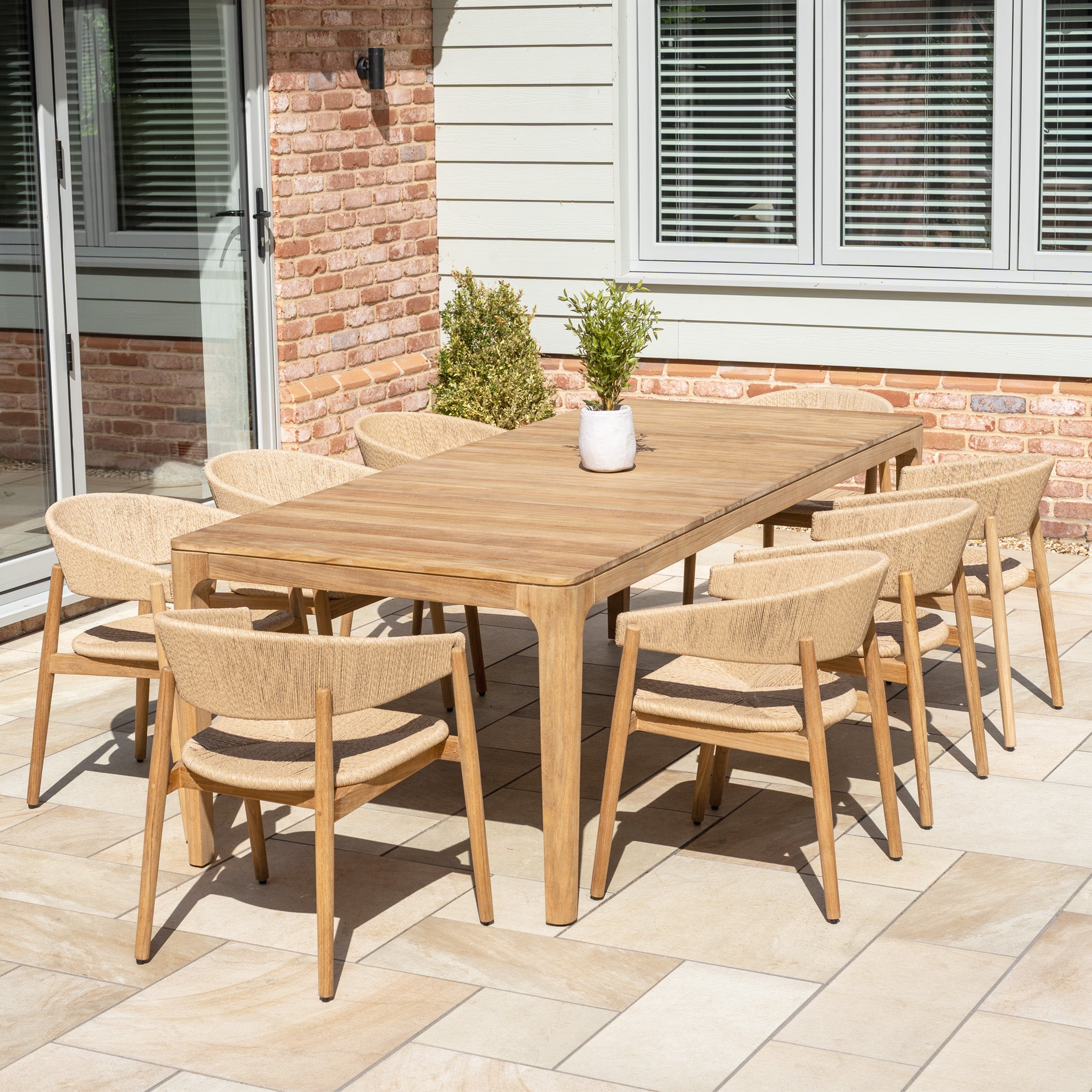The Lucca 8 Seat Dining Set with Teak Table in Natural Weave includes a spacious outdoor table and eight chairs, perfect for al fresco dining on your patio.