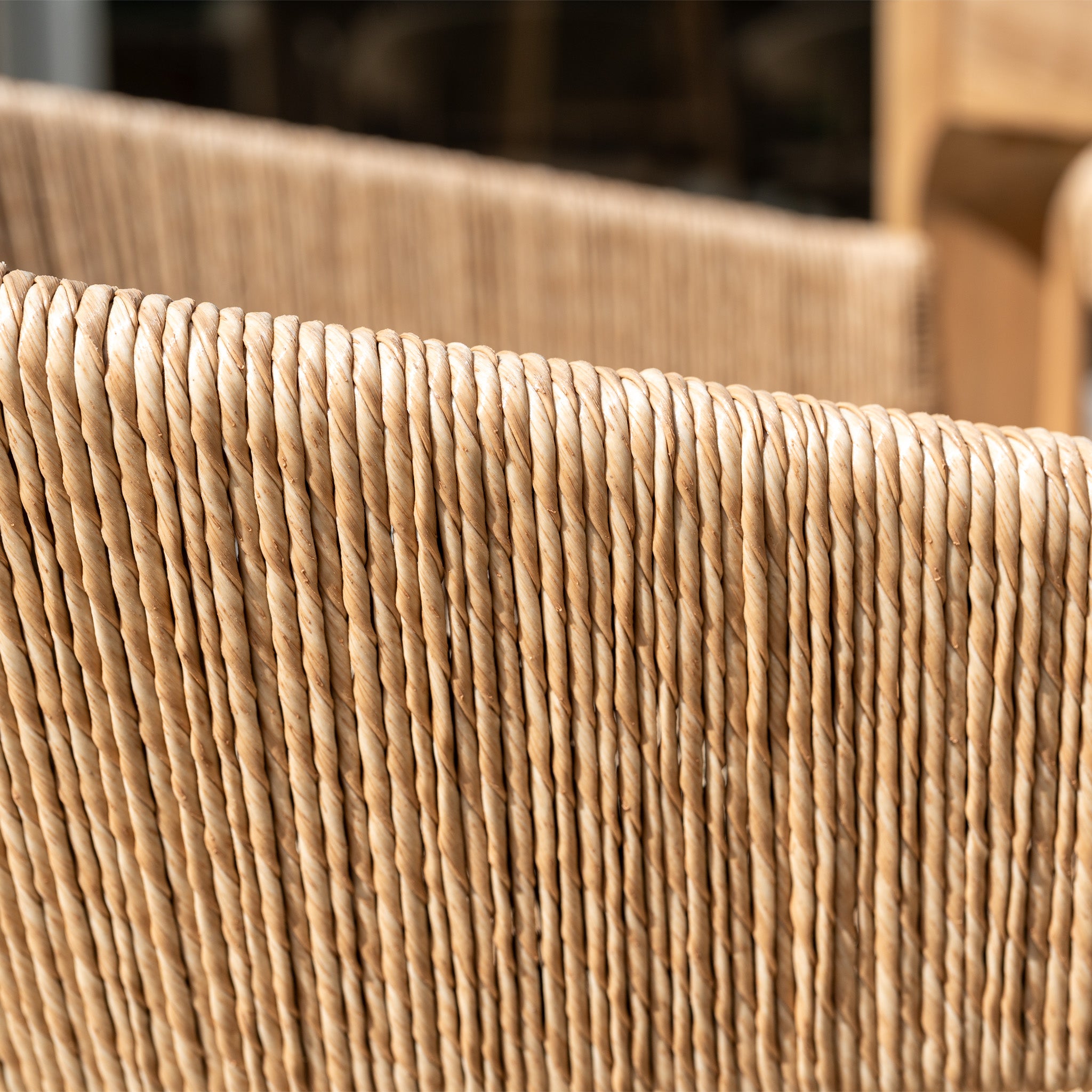 Close-up of the hand-woven wicker seat in the Lucca 8 Seat Dining Set with Teak Table in Natural Weave, highlighting the intricate texture and natural fiber patterns.