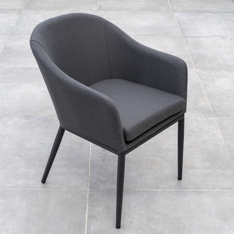 A set of two Luna Dining Chairs in grey, featuring modern upholstery and cushions, placed on a tiled floor.