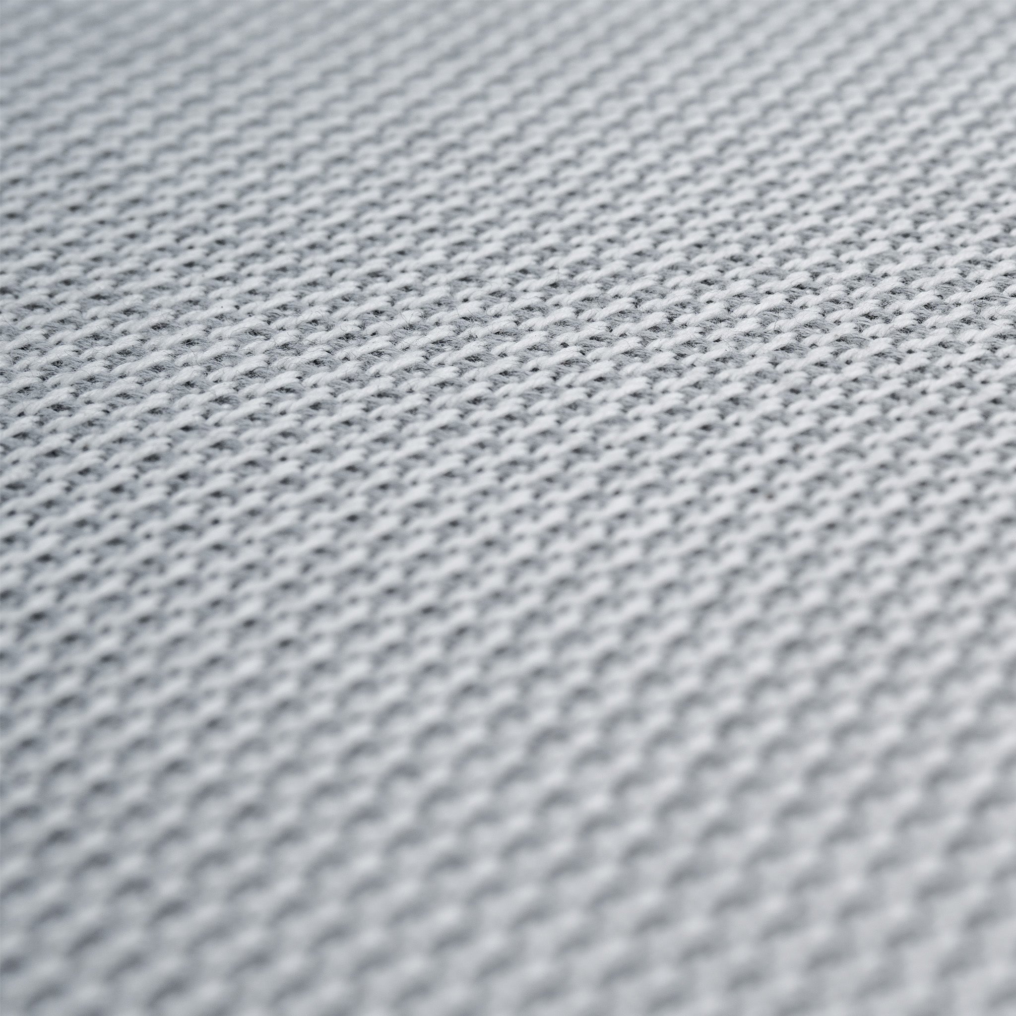 Close-up of a textured white fabric surface with a repeating grid-like pattern, similar to the quick-dry cushion fabric used on the Luna Stool in Oyster Grey.