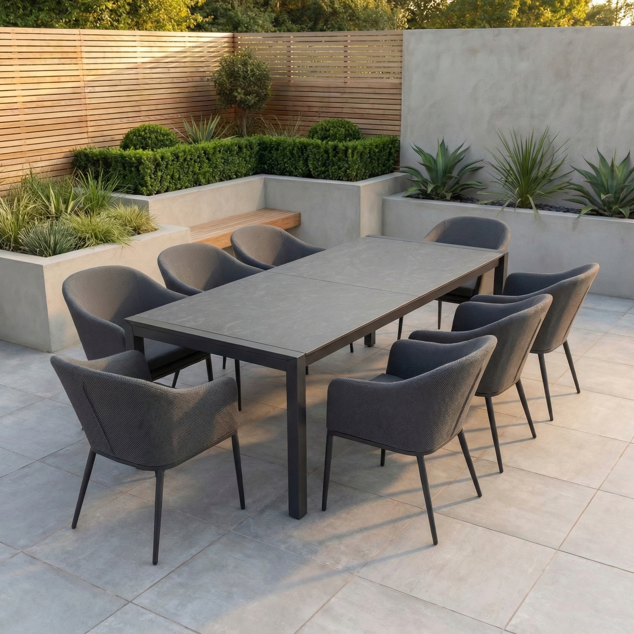 Contemporary patio with the Luna 10 Seat Outdoor Fabric Extending Ceramic Dining Set in Grey, featuring ten gray chairs and a large extending ceramic table, all made from durable all-weather materials on a tiled patio.