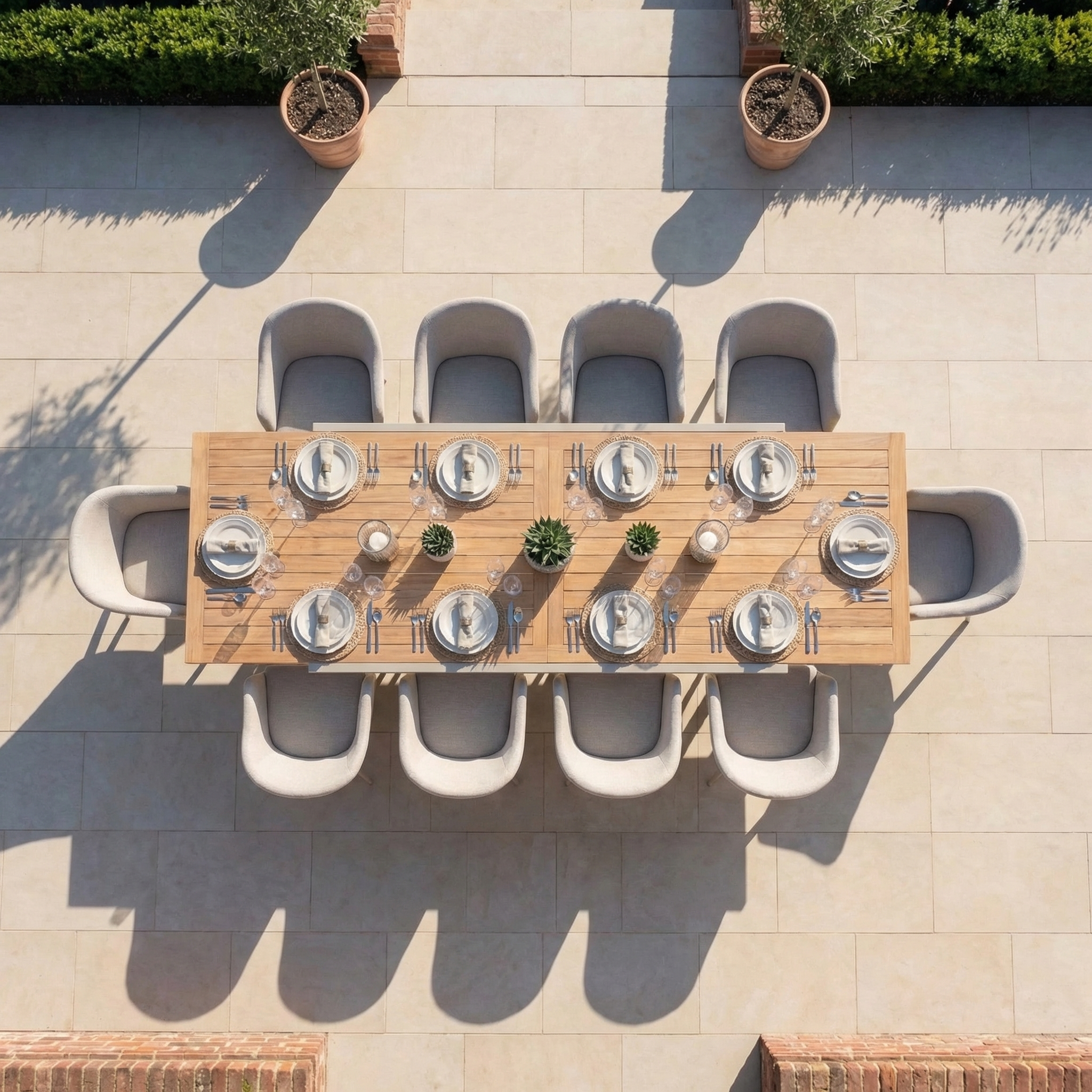 The Luna 10 Seat Outdoor Fabric Extending Teak Dining Set in Fawn, shown arranged with tableware and plants, offers a spacious, durable all-weather solution—perfect for outdoor gatherings.
