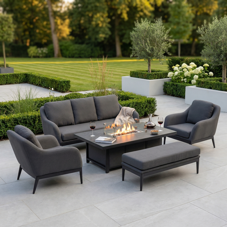 The Luna 3 Seat Outdoor Fabric Sofa Set with Rising Firepit Table in Grey offers lasting comfort and style on any patio, featuring durable all-weather material and perfect for outdoor spaces surrounded by greenery.