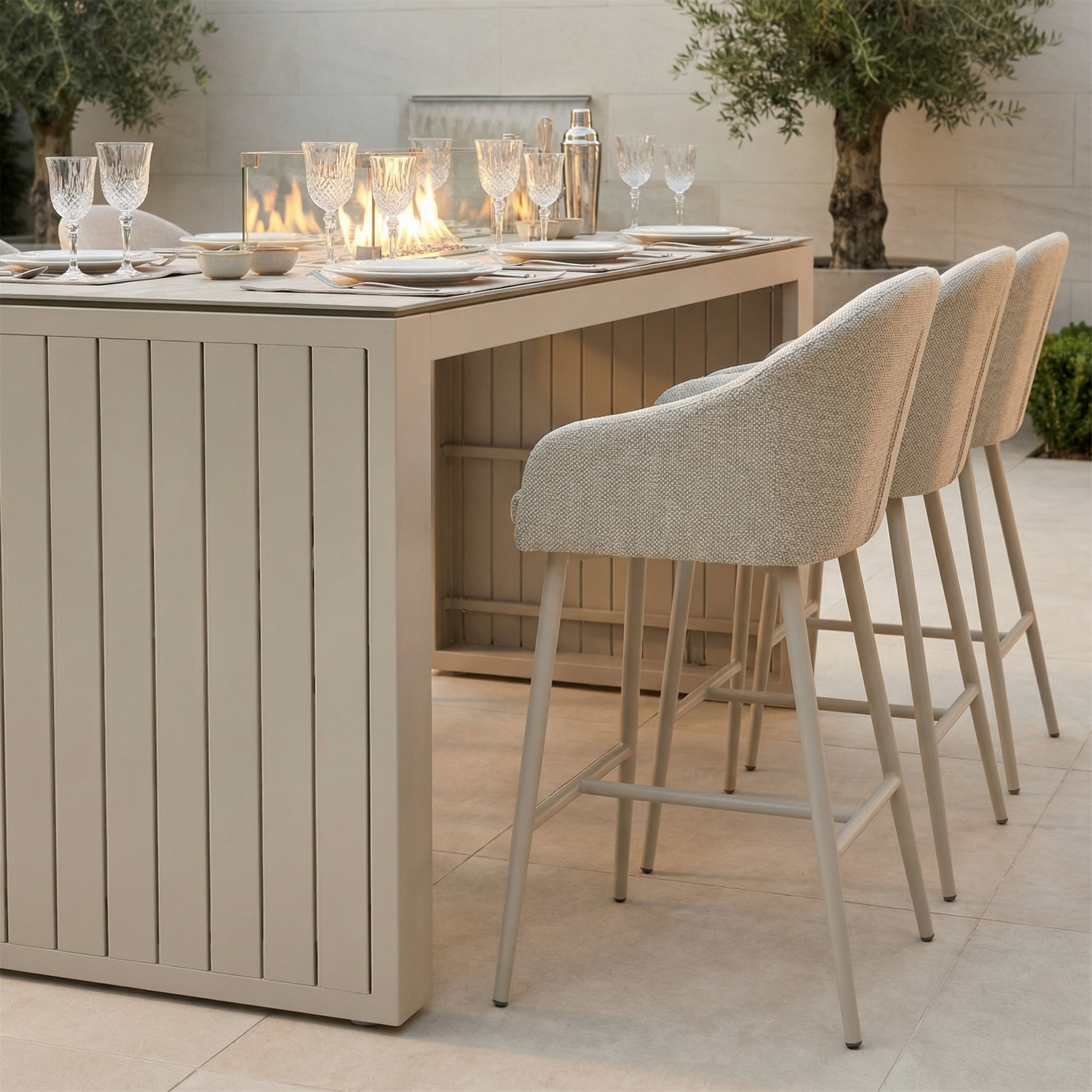 The Luna 6 Seat Outdoor Fabric Ceramic Firepit Bar Set in Fawn features bar stools, glassware, and a central firepit; made with all-weather materials for lasting durability, it brings style and functionality to your outdoor space.