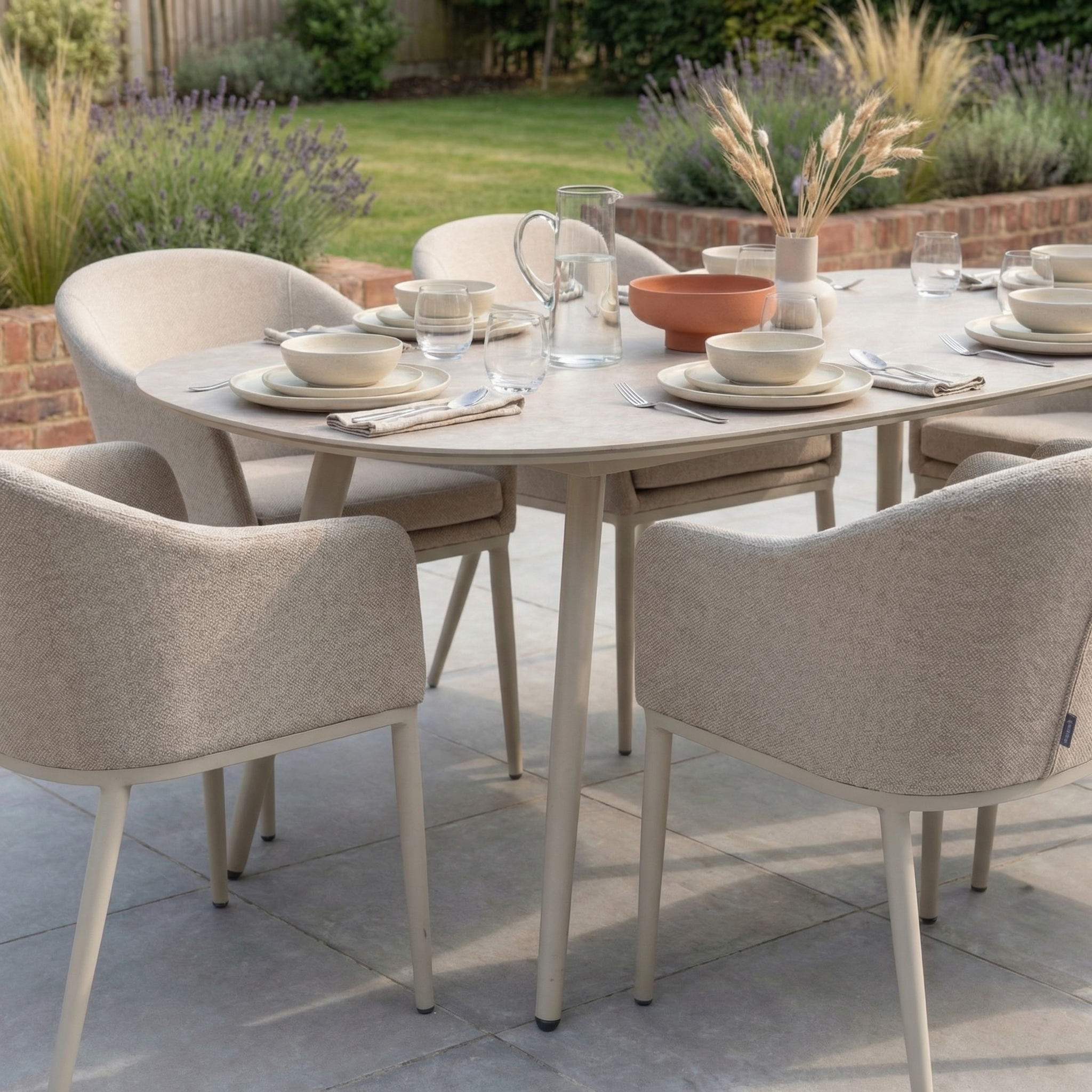 The Luna 6 Seat Outdoor Fabric Oval Ceramic Dining Set in Fawn features an all-weather ceramic table with cushioned chairs in Luna outdoor fabric, styled for six and perfect for al fresco dining.