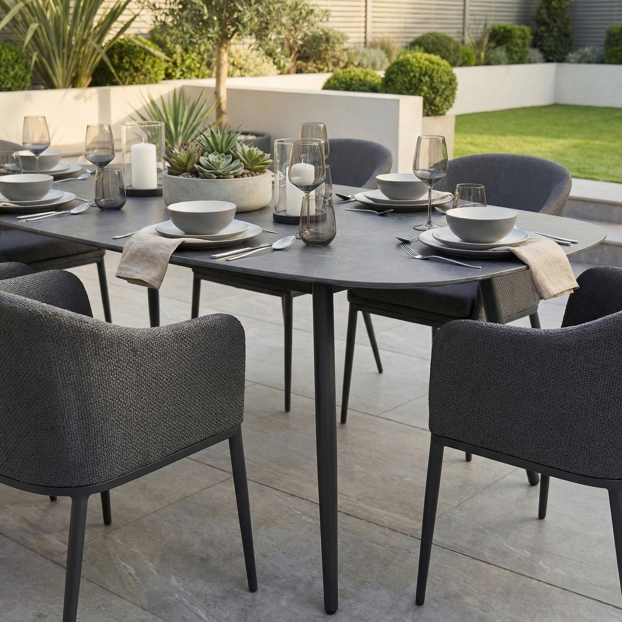 The Luna 6 Seat Outdoor Fabric Oval Ceramic Dining Set in Grey features stain-resistant chairs and a sleek, modern design—perfect for stylish garden patio dining for six.
