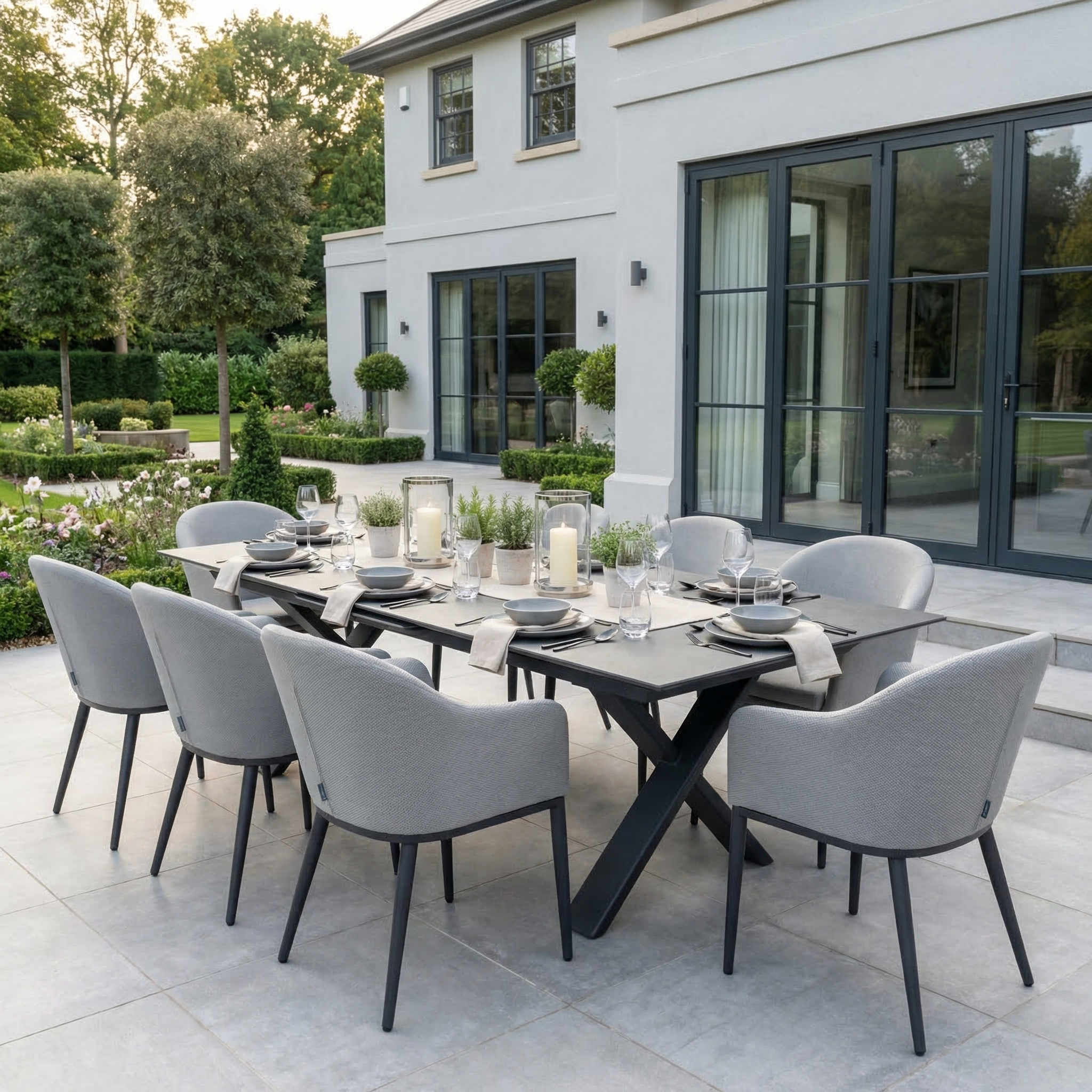 The Luna 8 Seat Outdoor Fabric Dining Set with Albatross Extending Table in Oyster Grey is perfectly placed for patio dining beside a stylish home.