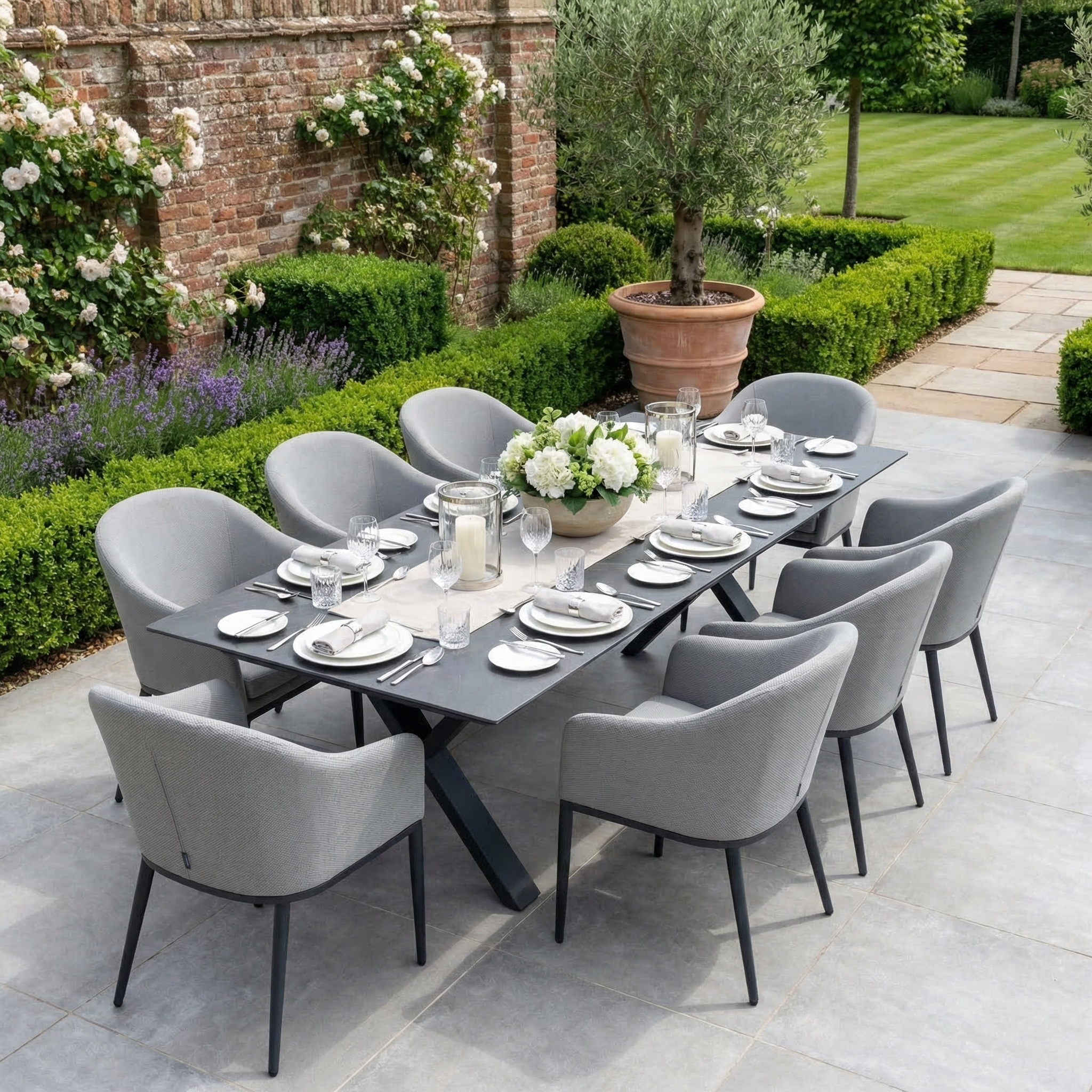 The Luna 8 Seat Outdoor Fabric Dining Set with Albatross Extending Table in Oyster Grey features gray chairs and is perfect for a landscaped garden patio.