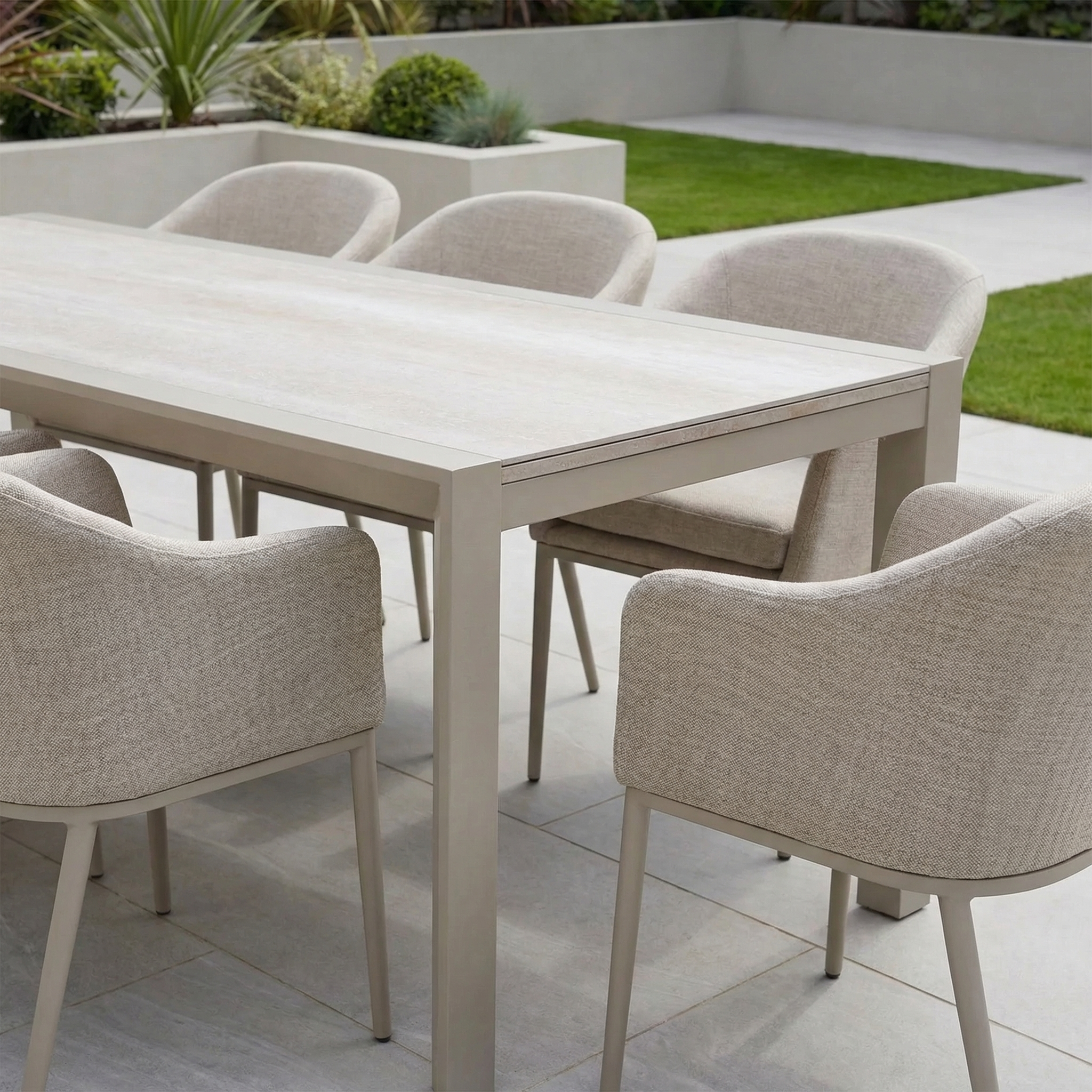 The Luna 8 Seat Outdoor Fabric Extending Ceramic Dining Set in Fawn features all-weather fabric chairs with beige cushions, arranged around a rectangular extending ceramic table, perfect for your patio or lawn.