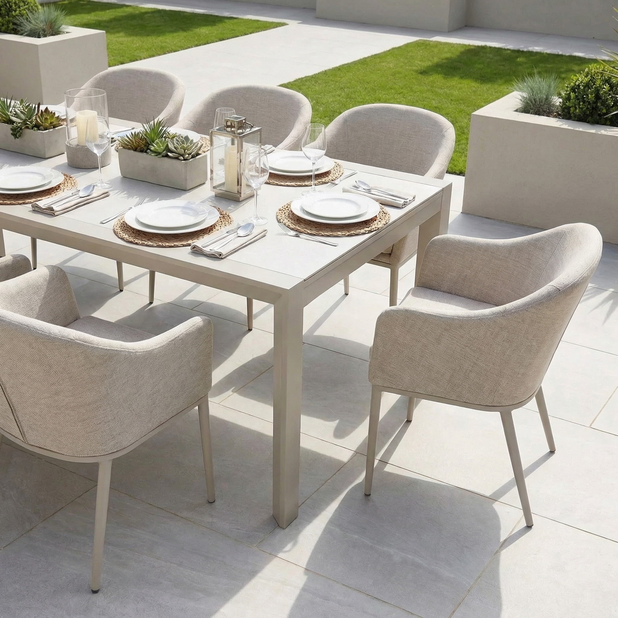 The Luna 8 Seat Outdoor Fabric Extending Ceramic Dining Set in Fawn features cushioned chairs and all-weather materials, perfect for outdoor meals on a tiled patio surrounded by lush greenery.