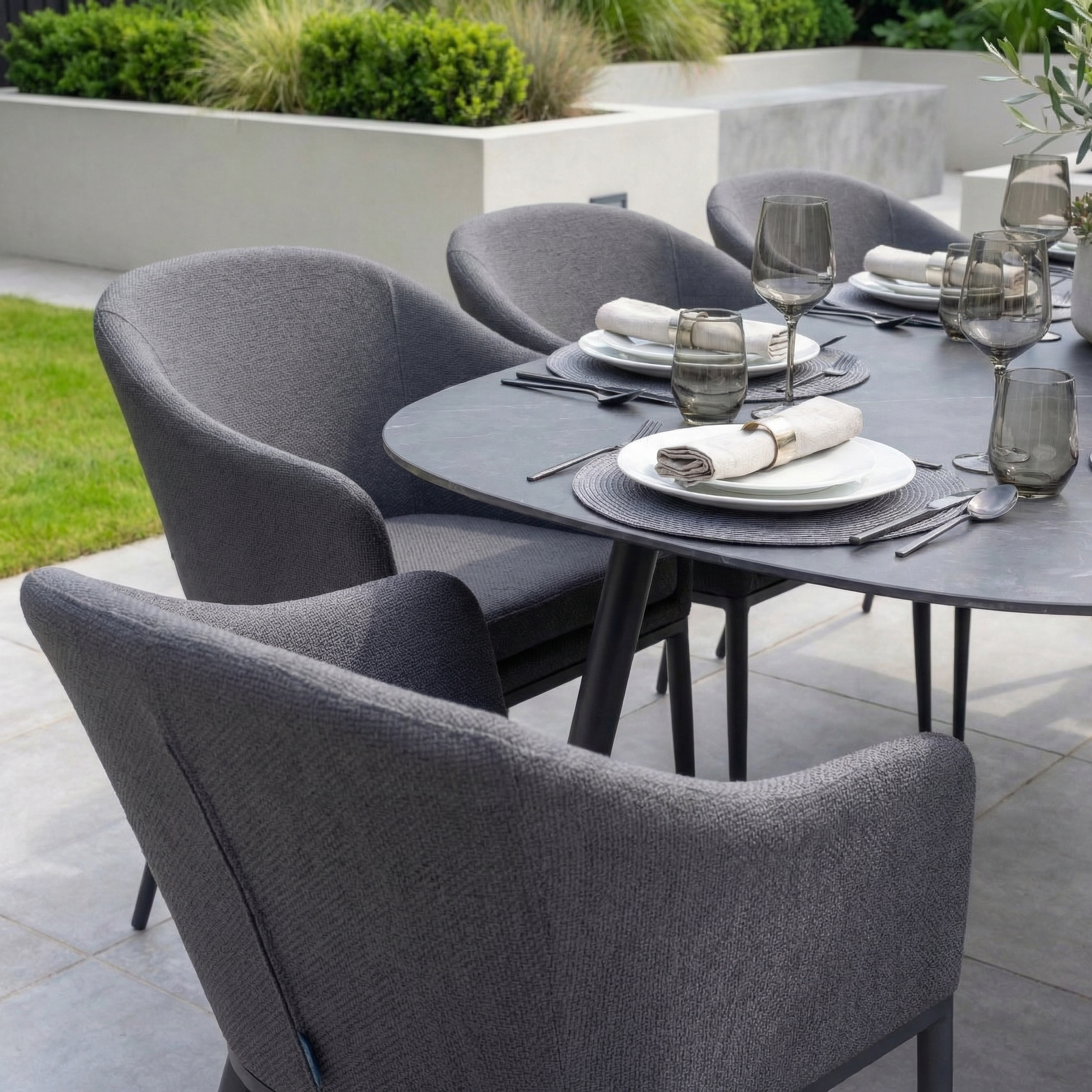 The Luna 8 Seat Outdoor Fabric Oval Ceramic Dining Set in Grey offers stylish, all-weather durability—ideal for gatherings with its spacious table and comfortable seating for eight.