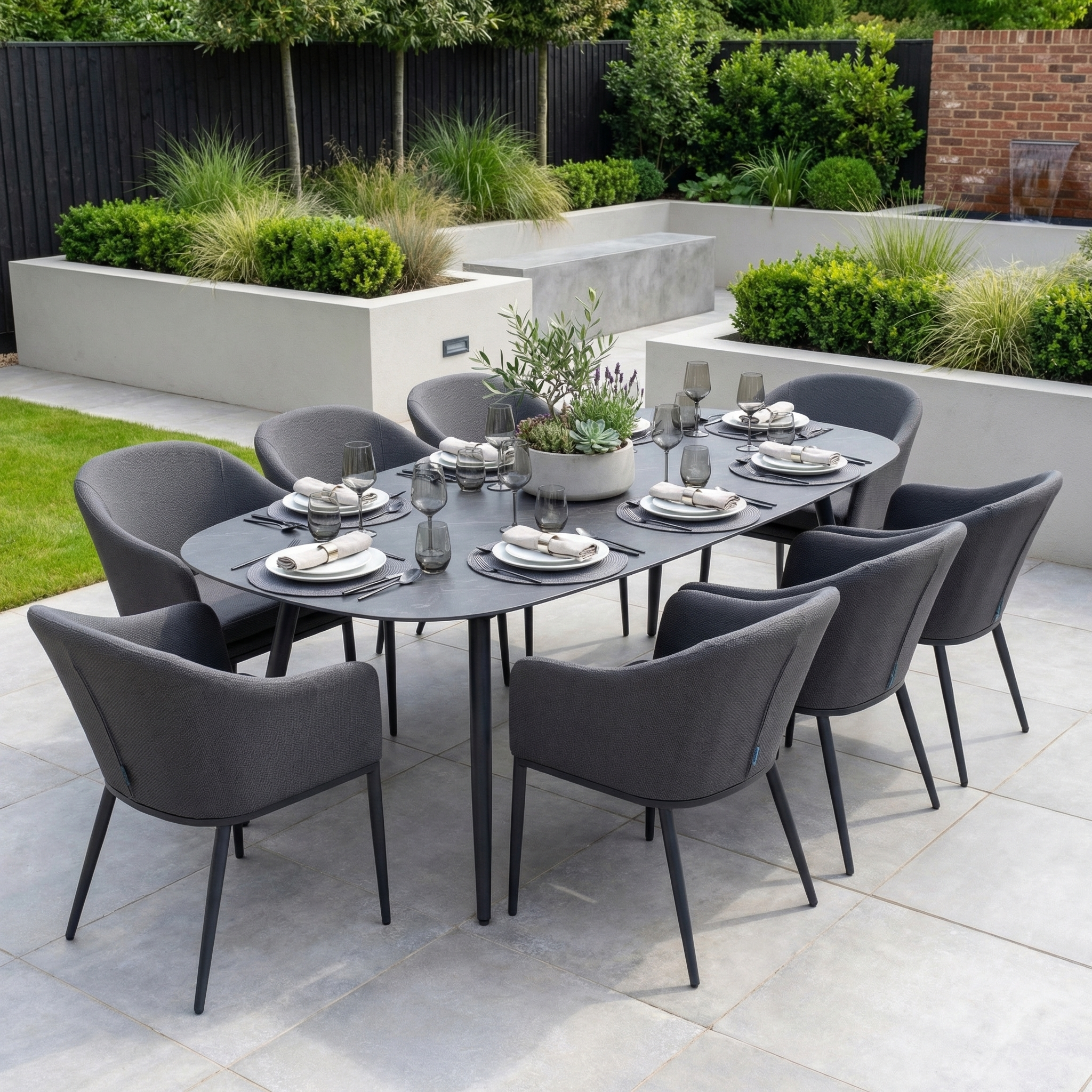 The Luna 8 Seat Outdoor Fabric Oval Ceramic Dining Set in Grey features upholstered chairs and a dark oval table, making it perfect for any patio.