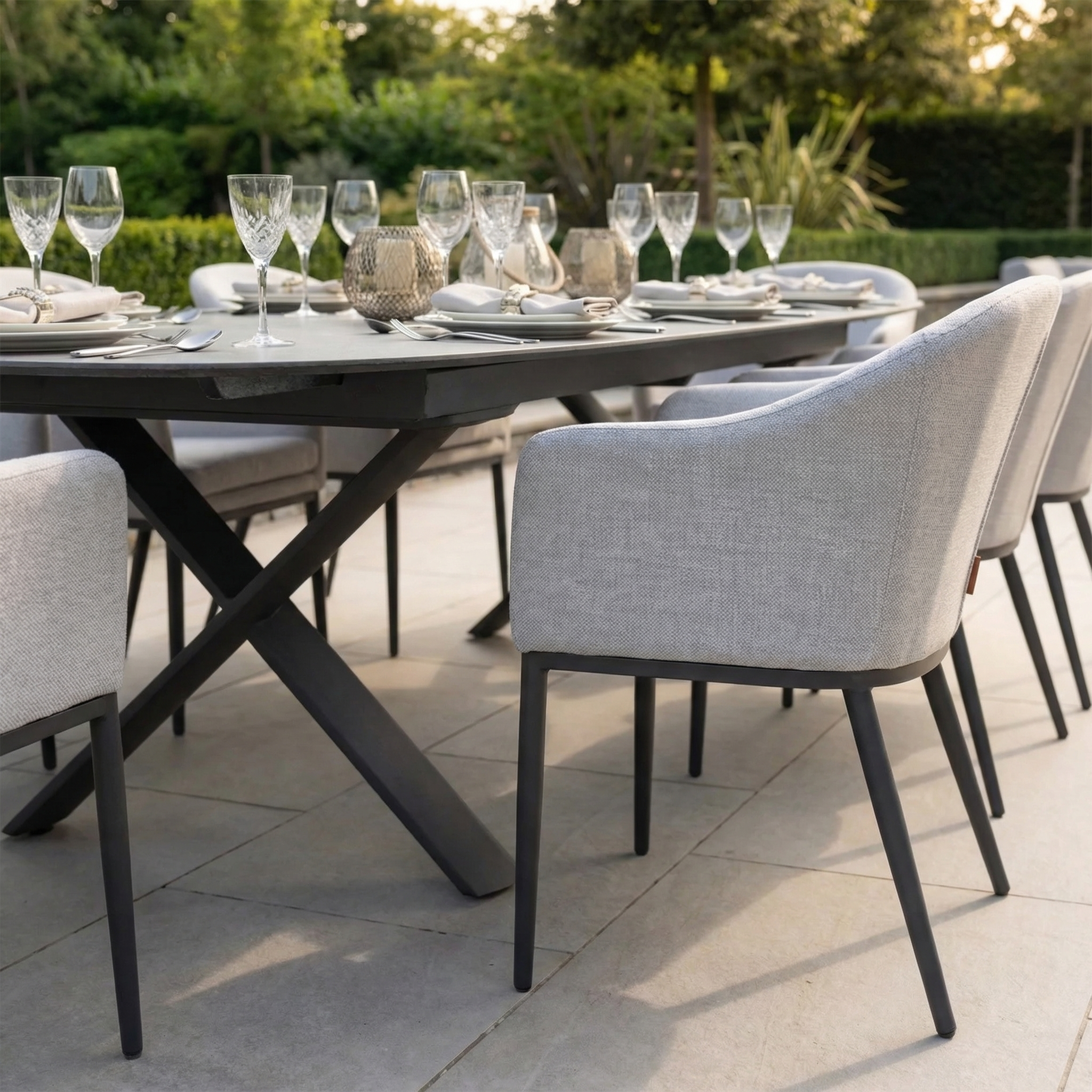 The Luna 8 Seat Outdoor Fabric Oval Dining Set with Albatross Extending Table in Oyster Grey features elegant outdoor seating, an extending table, and durable grey UV-resistant cushions for a stylish patio.