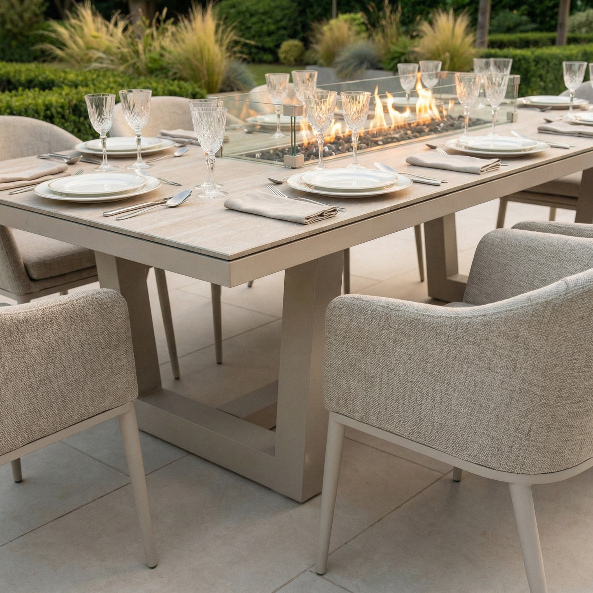 The Luna 8 Seat Outdoor Fabric Rectangular Ceramic Firepit Dining Set in Fawn features a built-in fire centerpiece and cushioned chairs with all-weather Luna fabric, complete with plates and glassware for elegant outdoor dining.