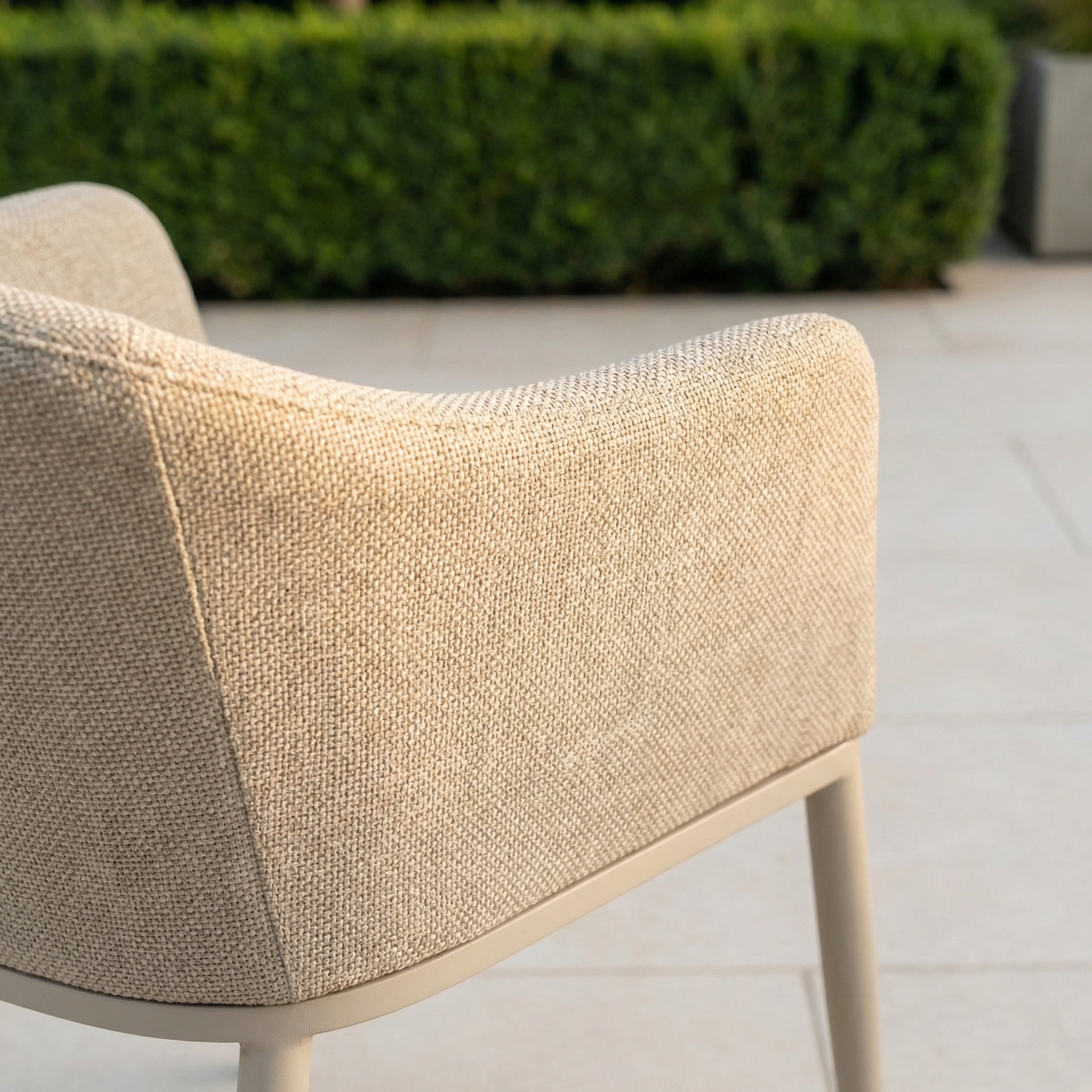 The Luna 8 Seat Outdoor Fabric Rectangular Ceramic Firepit Dining Set in Fawn features beige upholstered chairs crafted with durable Luna outdoor fabric, ideal for patios surrounded by greenery and perfect for your firepit dining experience.