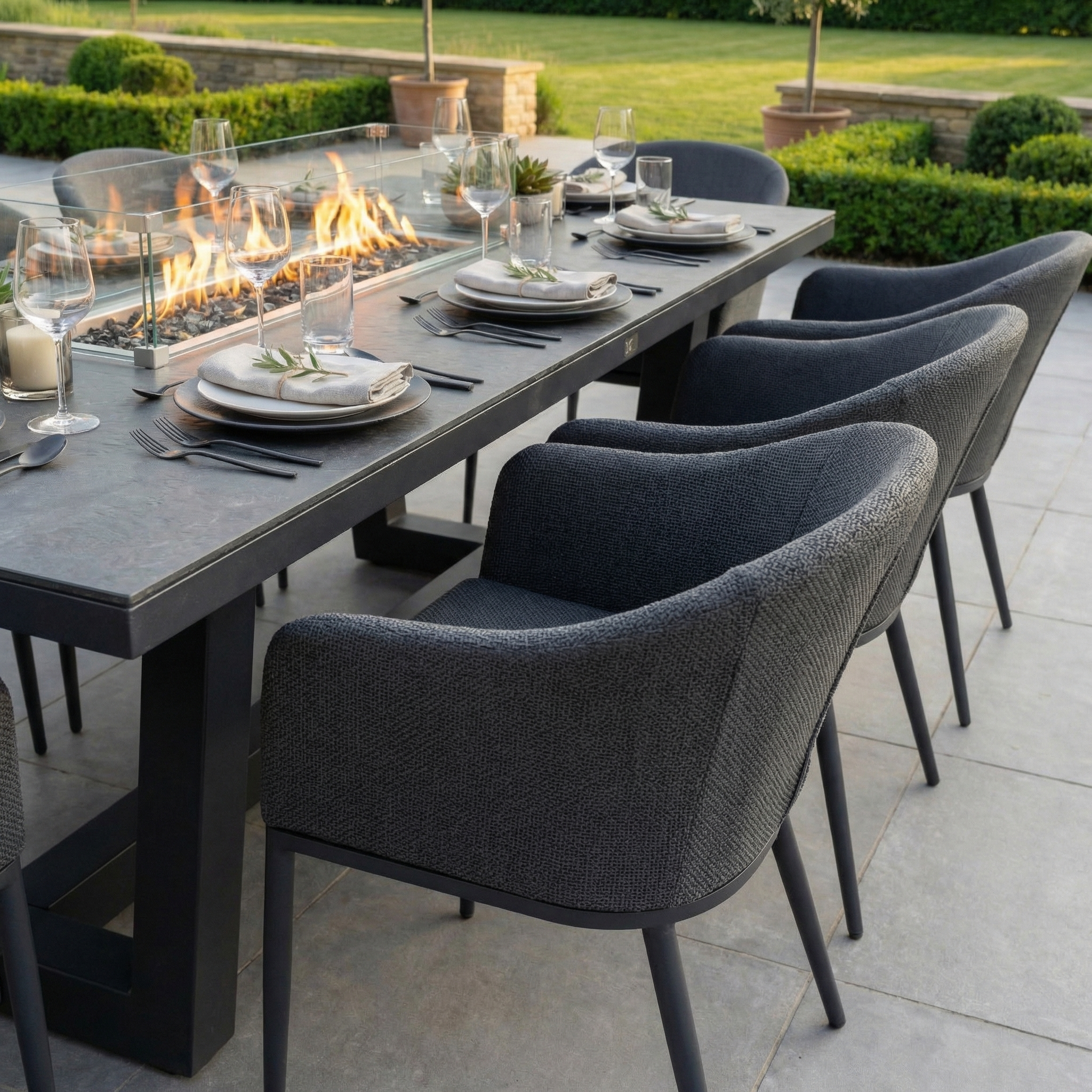 The Luna 8 Seat Outdoor Fabric Rectangular Ceramic Firepit Dining Set in Grey creates a stylish, inviting patio space with grey chairs and an all-weather ceramic firepit table, perfect for outdoor dining.