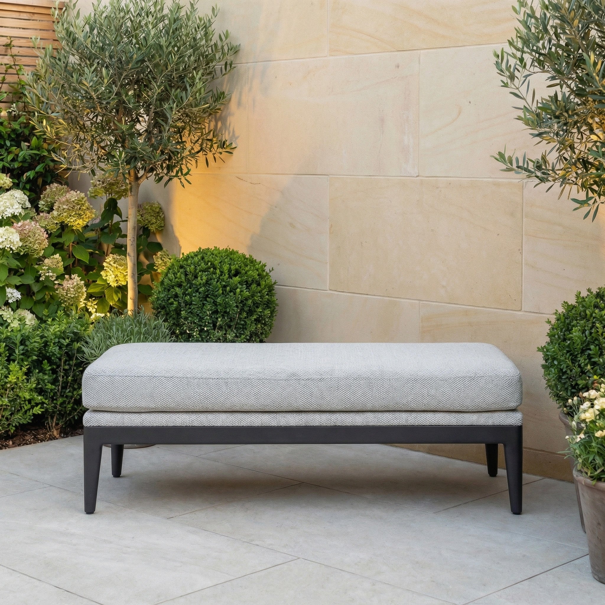 The Luna Bench in Oyster Grey features a comfortable cushion and is ideal as an all-weather seating option for your garden or patio retreat.