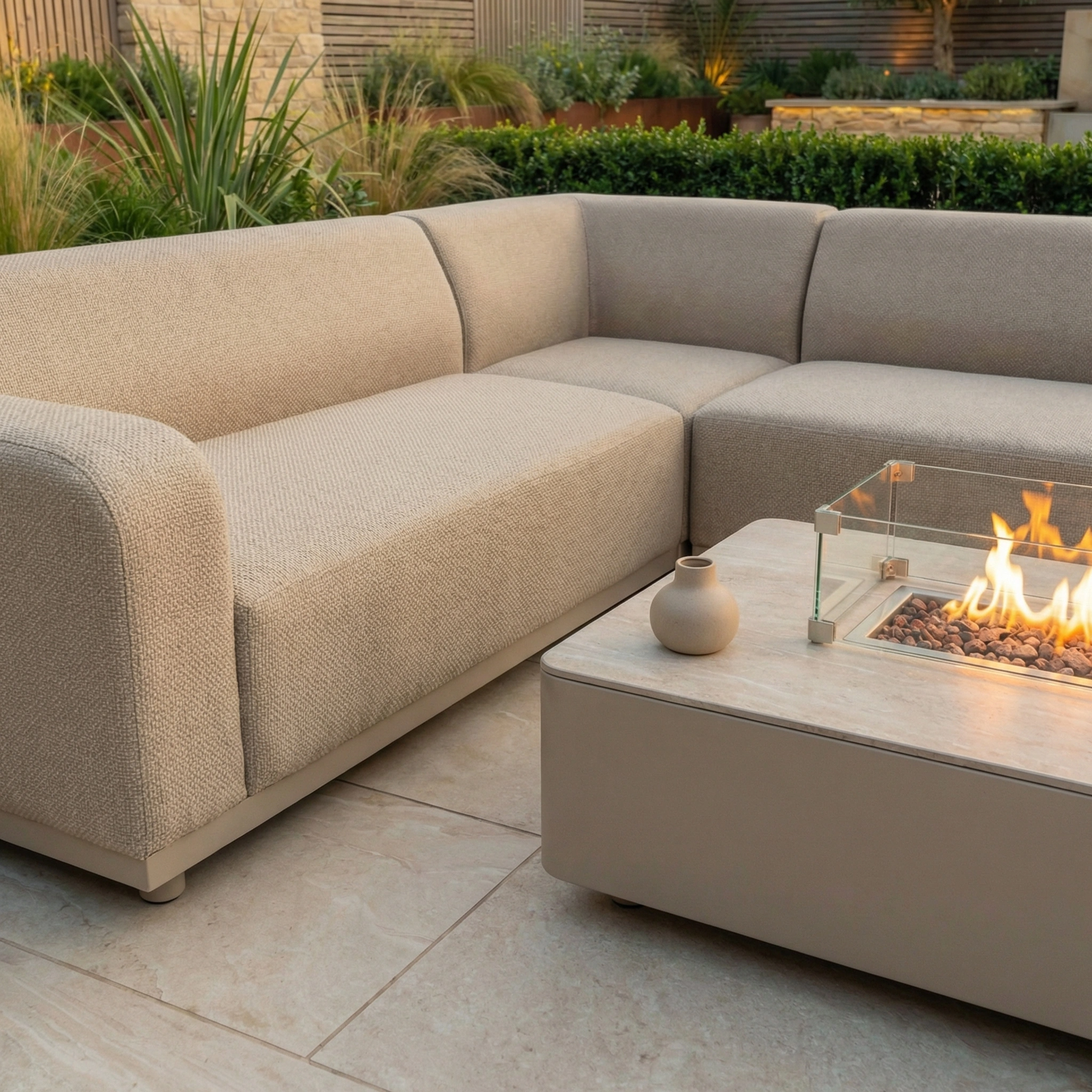 Luna Outdoor Fabric Corner Sofa Set with Firepit Coffee Table in Fawn—ideal for a landscaped garden patio.