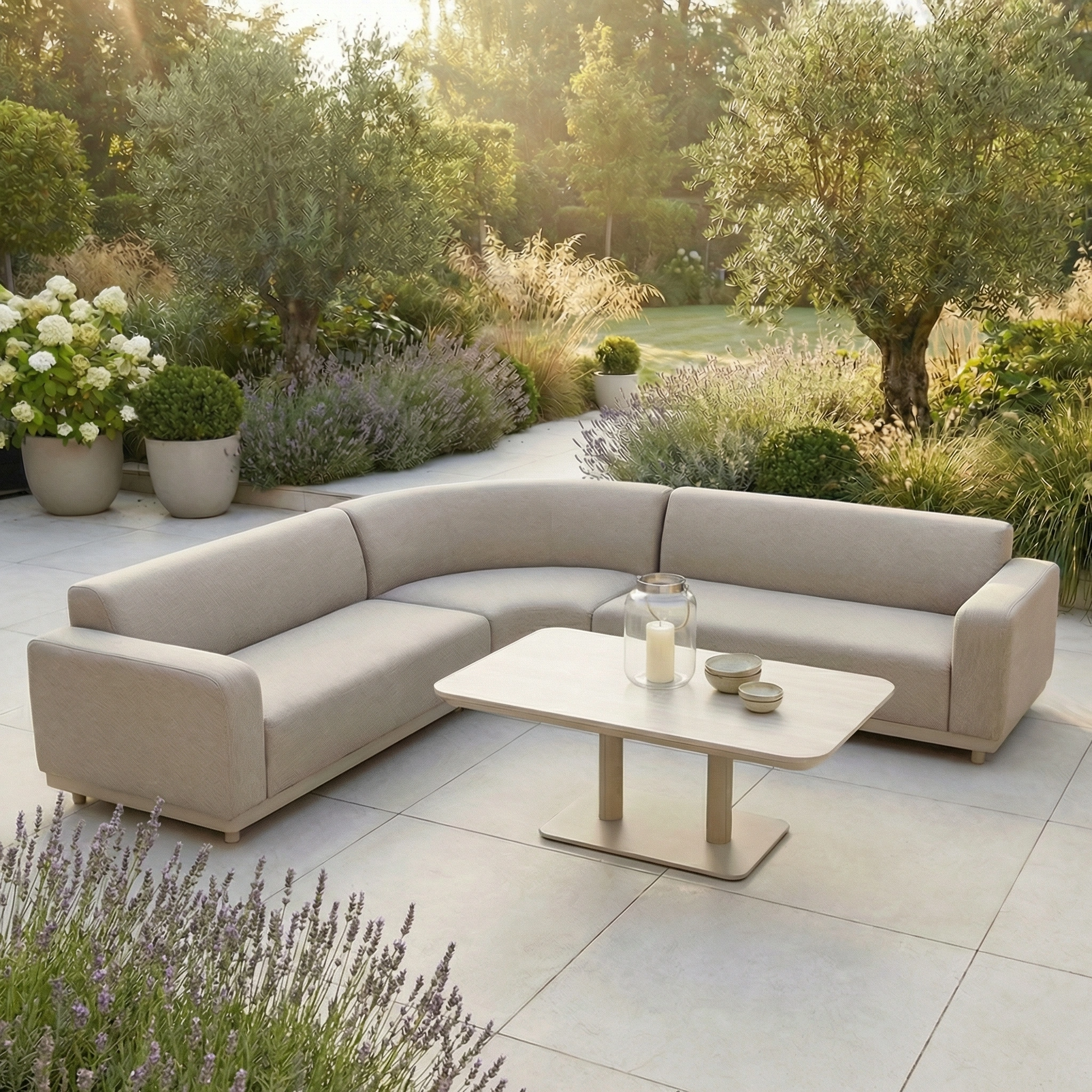 The Luna Outdoor Fabric Curved Corner Sofa Set with Altura Rising Table in Fawn offers stylish all-weather comfort for your patio, surrounded by greenery—ideal garden furniture for relaxing outside.