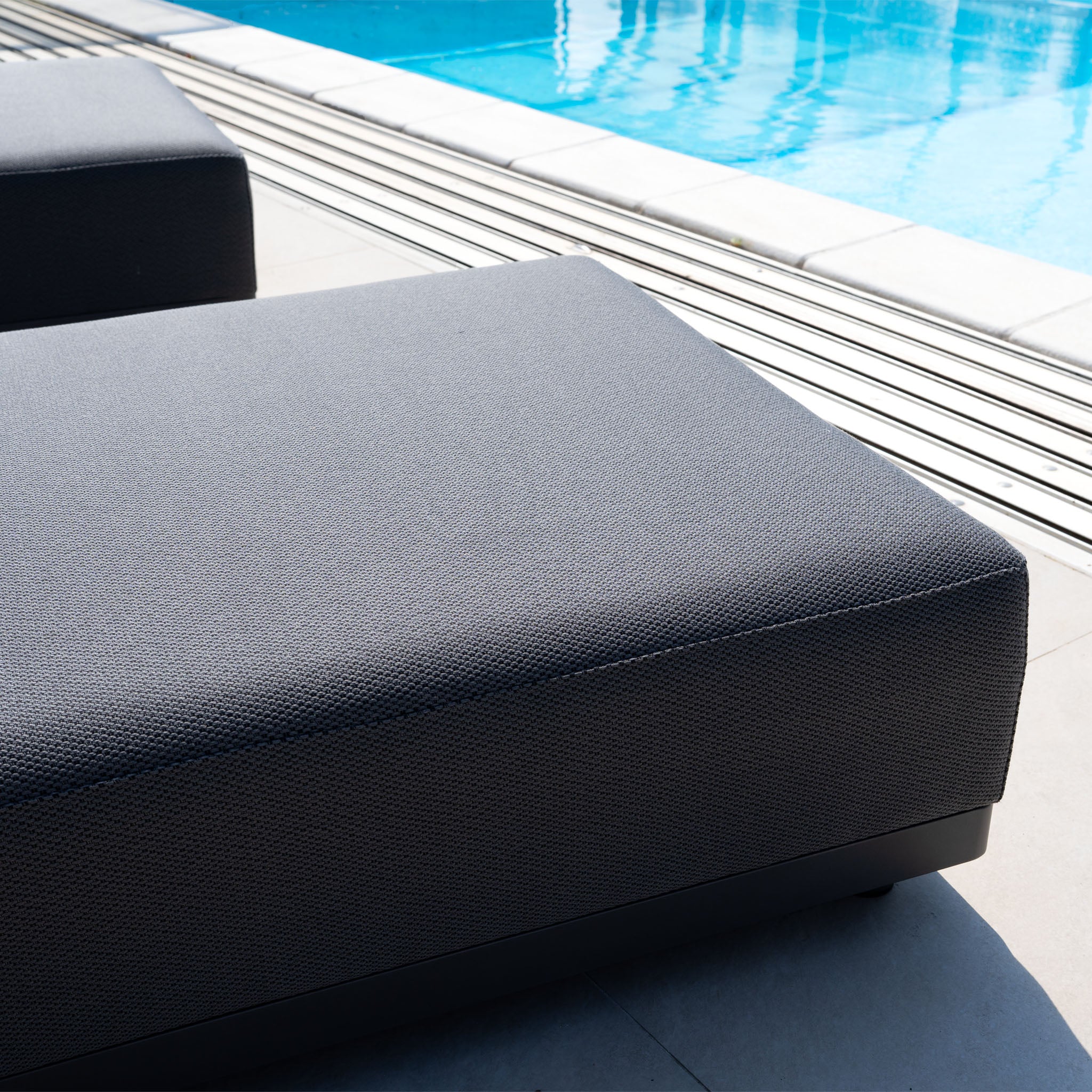 The Luna Outdoor Fabric Deluxe Sun Lounger with Bolster Cushion in Grey is the perfect elegant addition to your poolside on a sunny day.