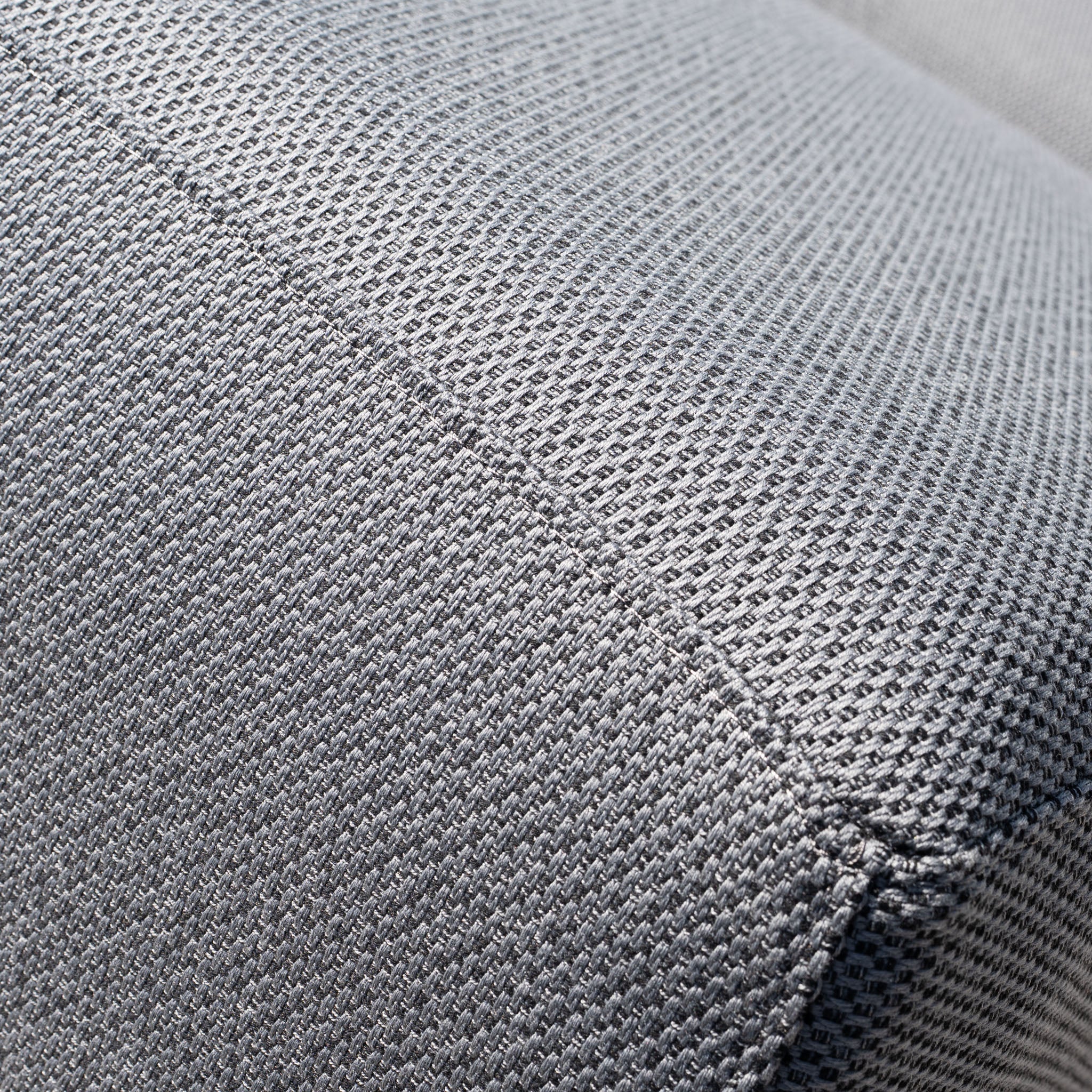 Close-up of grey Luna Outdoor Fabric Deluxe Sun Lounger with Bolster Cushion, featuring visible stitching and crafted from durable solution-dyed acrylic fabric.