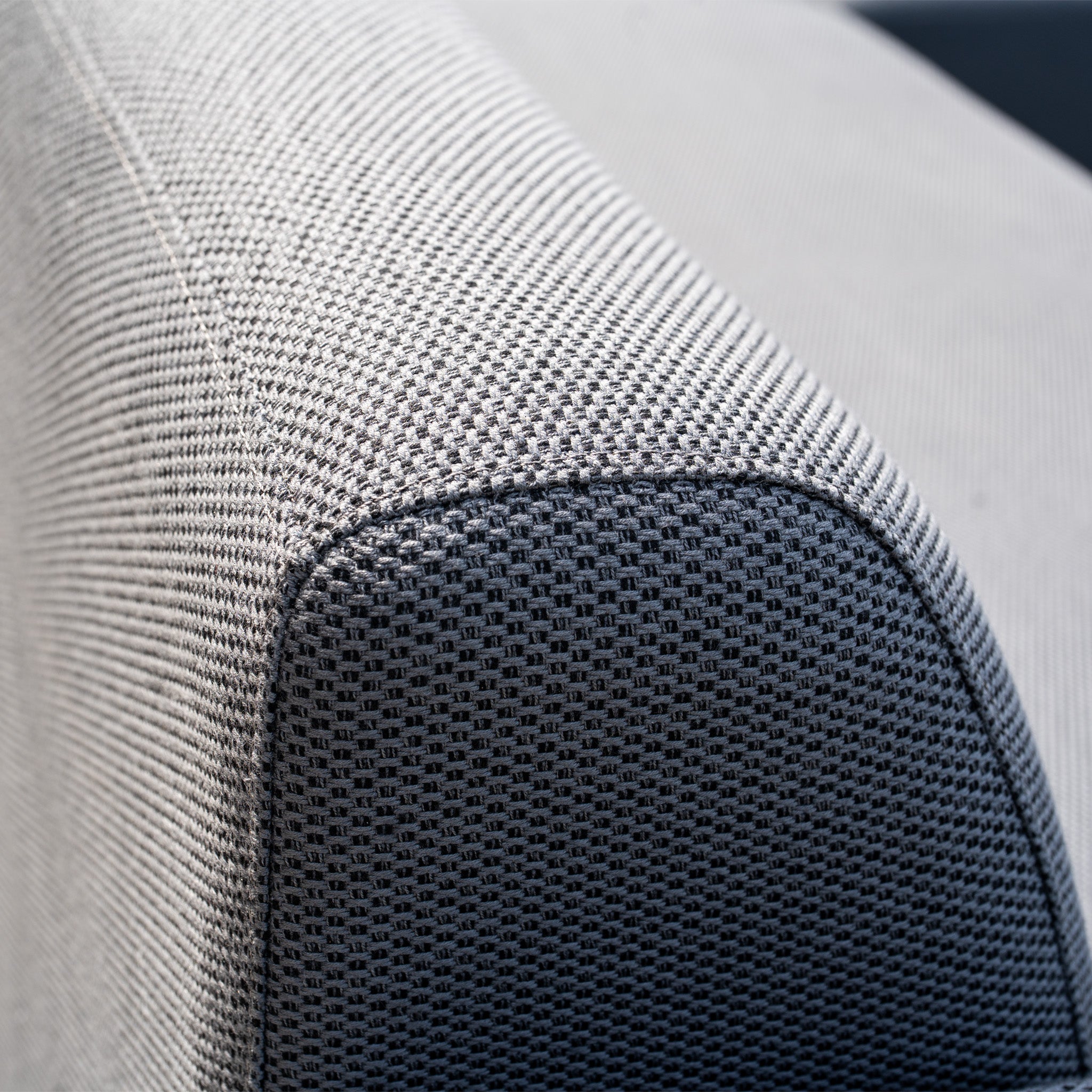 Close-up of the Luna Outdoor Fabric Large Corner Sofa Set with Altura Rising Table in Grey, showcasing the textured armrest, detailed stitching, and stain-resistant finish.