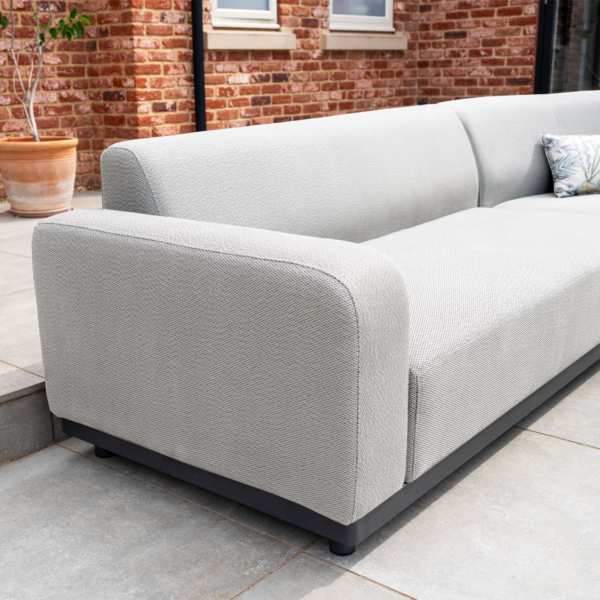 Oyster Grey Luna Outdoor Fabric Large Curved Corner Group Set with rounded arms and Round Firepit Coffee Table, ideal for stylish outdoor furniture arrangements on patios or in gardens.