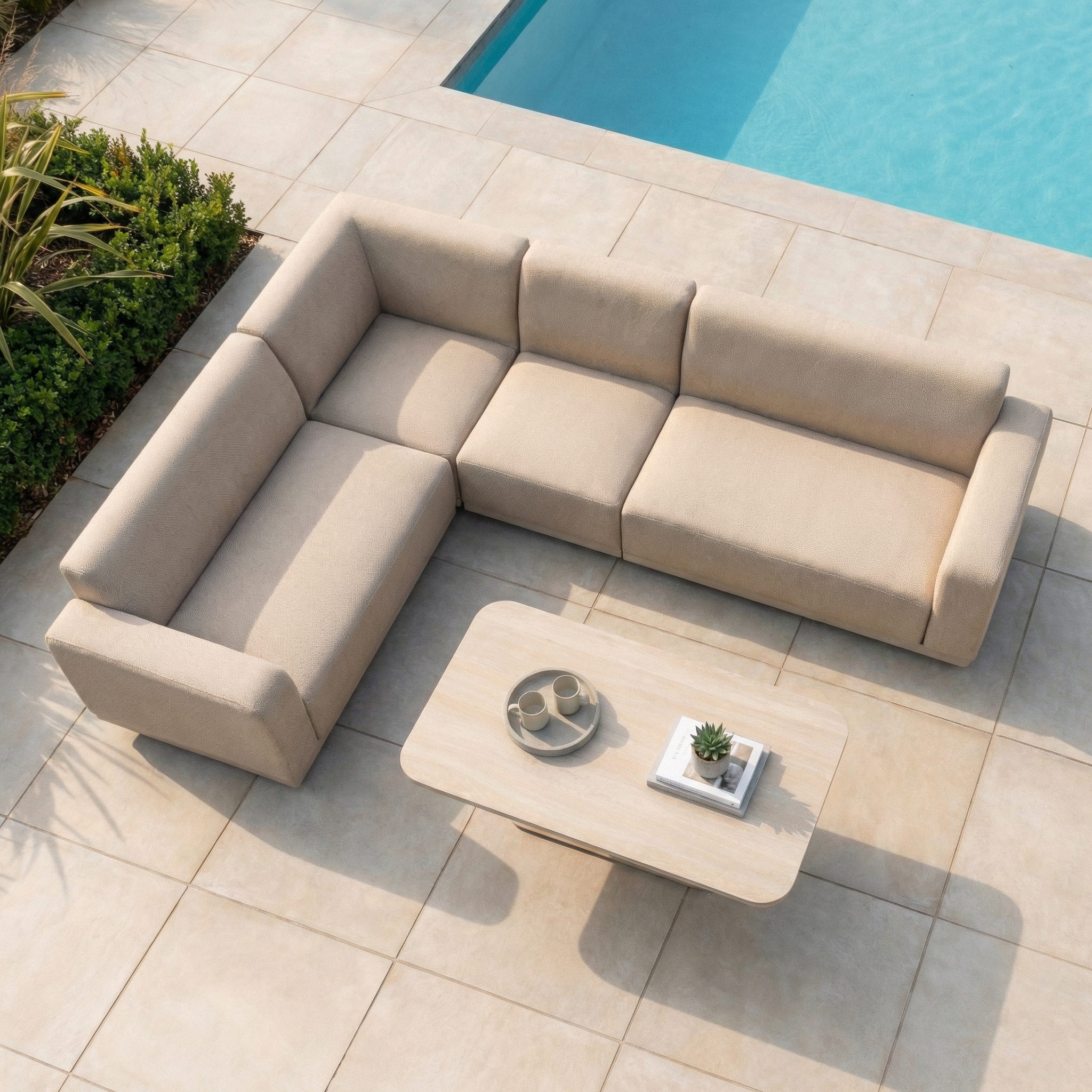 The Luna Outdoor Fabric Large Corner Sofa Set with Altura Rising Table in Fawn features weather-resistant material and durable outdoor fabric, set beside a swimming pool on a tiled patio.