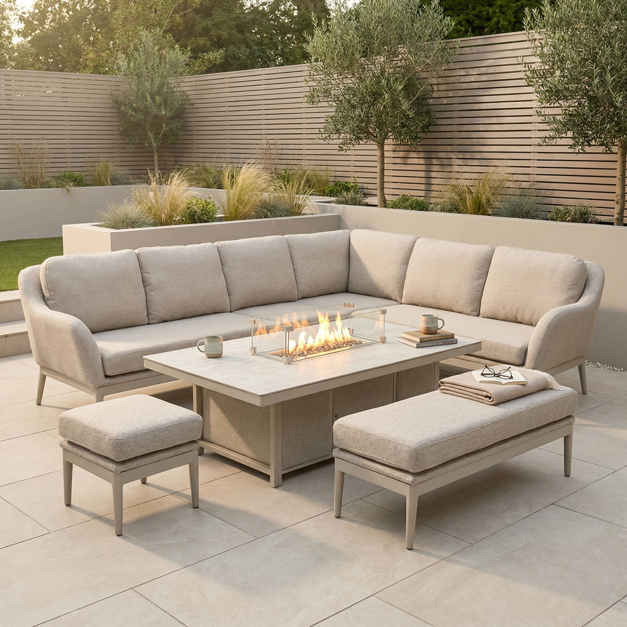 The Luna Outdoor Fabric Rectangular Corner Dining Set in Fawn (Right Hand) features a rising firepit table, benches, and is perfect for modern patio gardens with lush greenery.