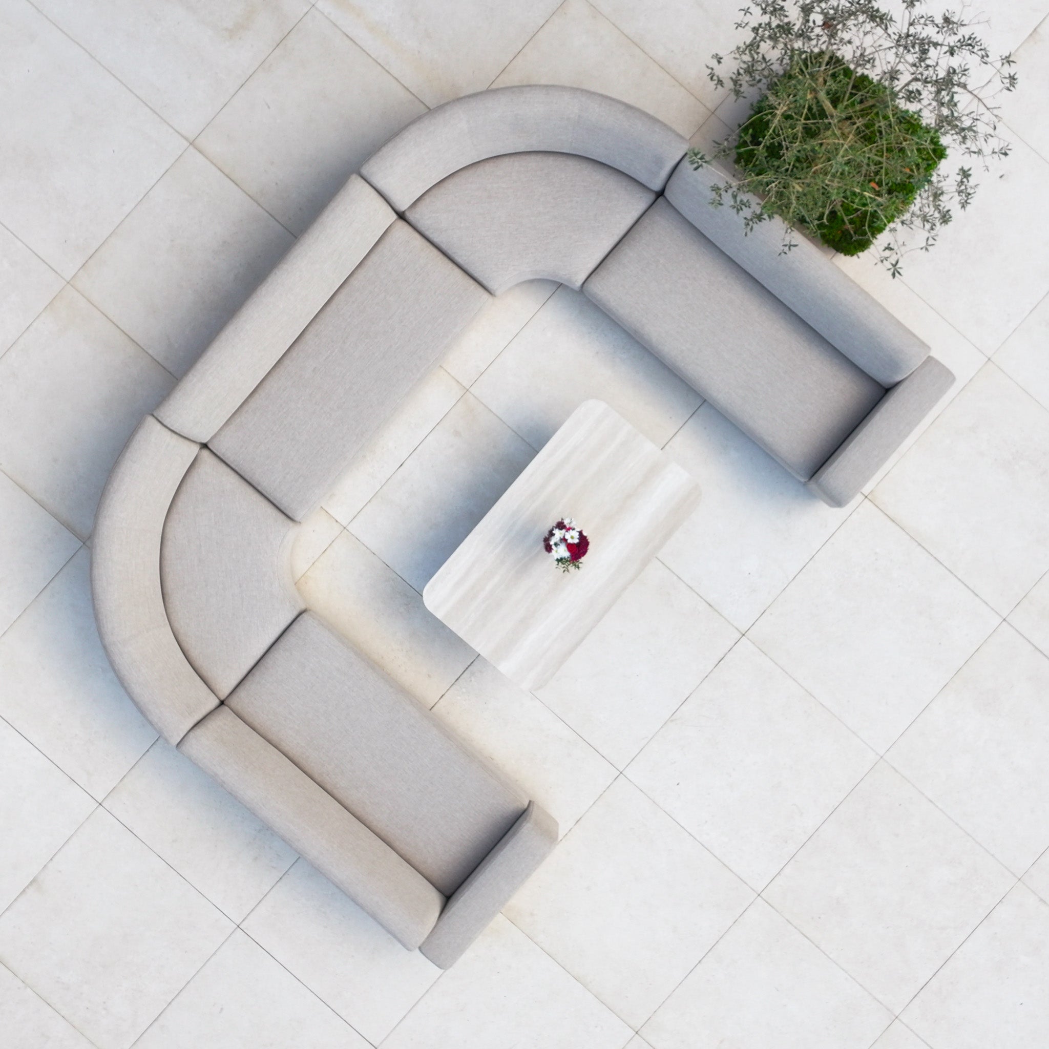 The Luna Outdoor Fabric Curved U-Shape Sofa Set with Altura Rising Table in Fawn creates a stylish, comfortable retreat on tiled flooring—seen from above, it features all-weather garden furniture perfect for outdoor relaxation.