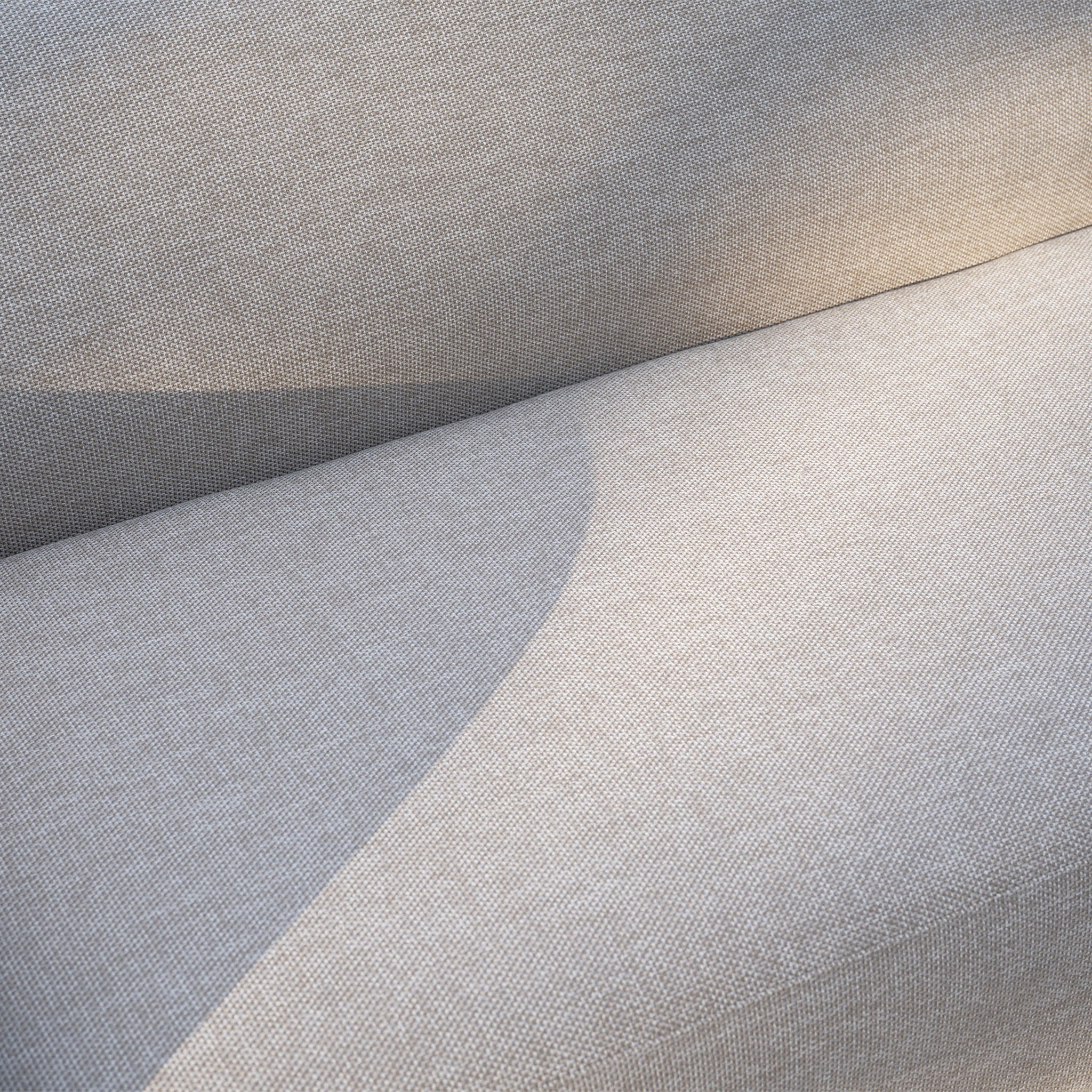 Close-up of the Luna U-Shape Outdoor Fabric Sofa Set with Altura Rising Table in Fawn, sunlight casting gentle shadows—stylish, weather-resistant garden furniture perfect for any outdoor setting.