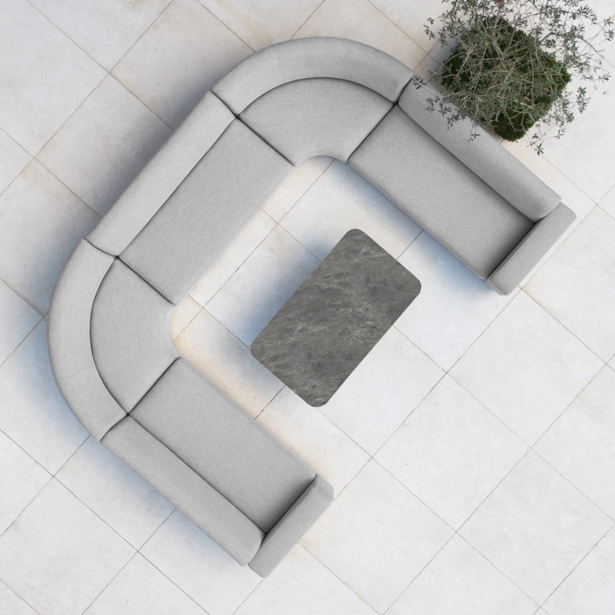 The Luna Outdoor Fabric Curved U-Shape Sofa Set with Altura Rising Table in Oyster Grey sits on a tiled floor, viewed from above—an inviting all-weather set for stylish patios, featuring a rectangular table and a potted plant.
