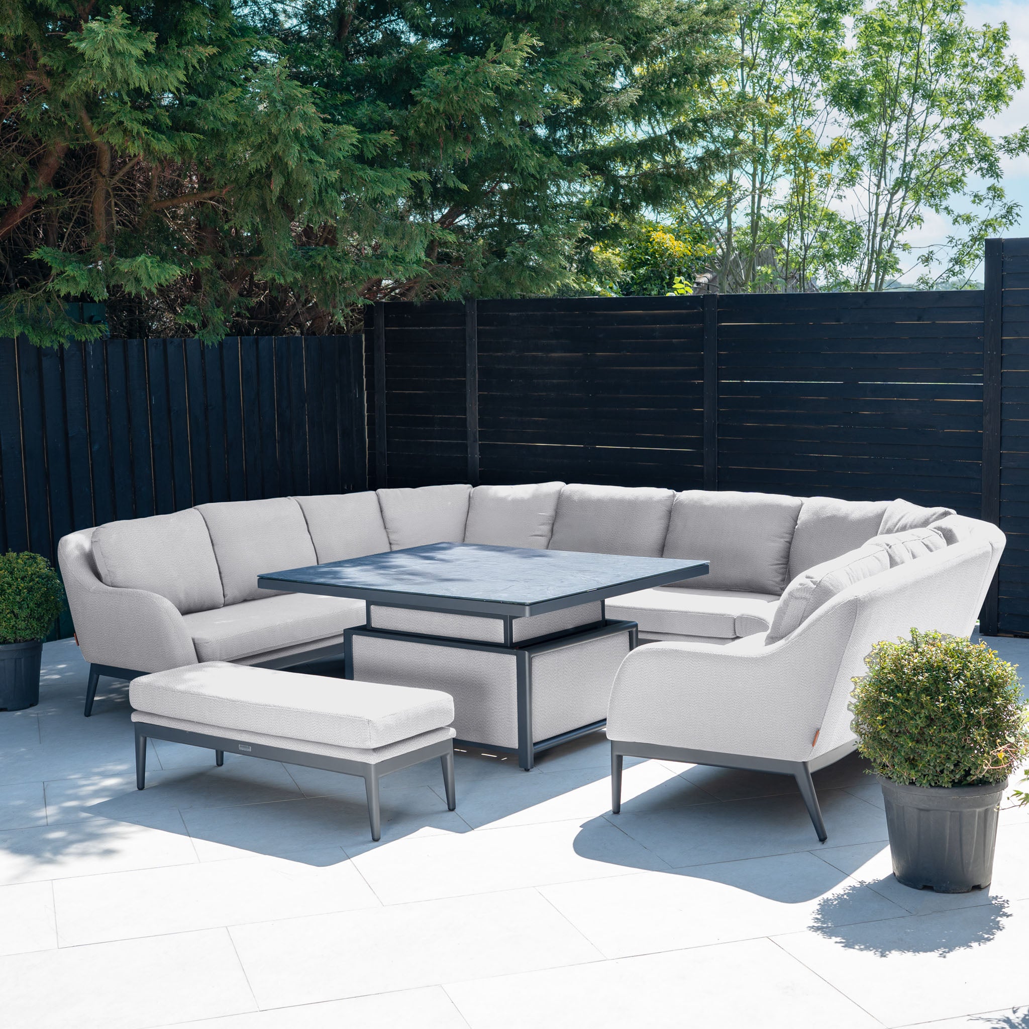 The Luna U-Shape Outdoor Fabric Corner Dining with Rising Table in Oyster Grey features all-weather cushions and a sleek rectangular rising table, perfect for sunny outdoor gatherings.