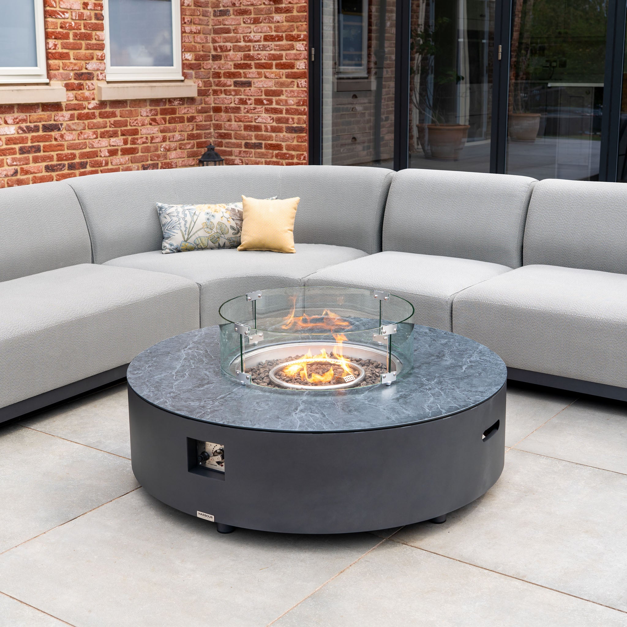 The Luna U-Shape Outdoor Fabric Curved Corner Group with Round Firepit Coffee Table in Oyster Grey features plush sectional seating and a glass-shielded fire pit—an elegant, all-weather patio set for stylish outdoor entertaining.