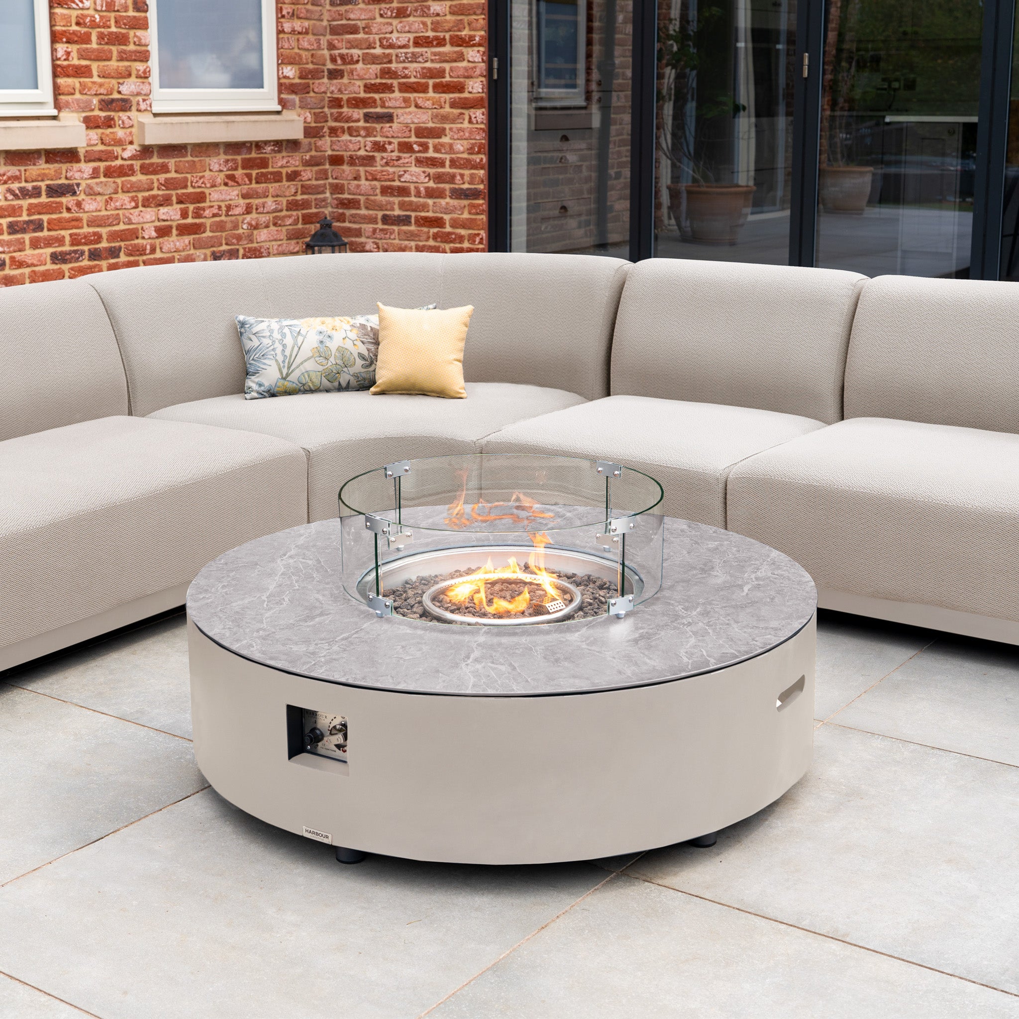 The Luna U-Shape Outdoor Fabric Curved Corner Group with Round Firepit Coffee Table in Fawn creates a stylish patio setup, featuring a curved sectional sofa around the round firepit coffee table.