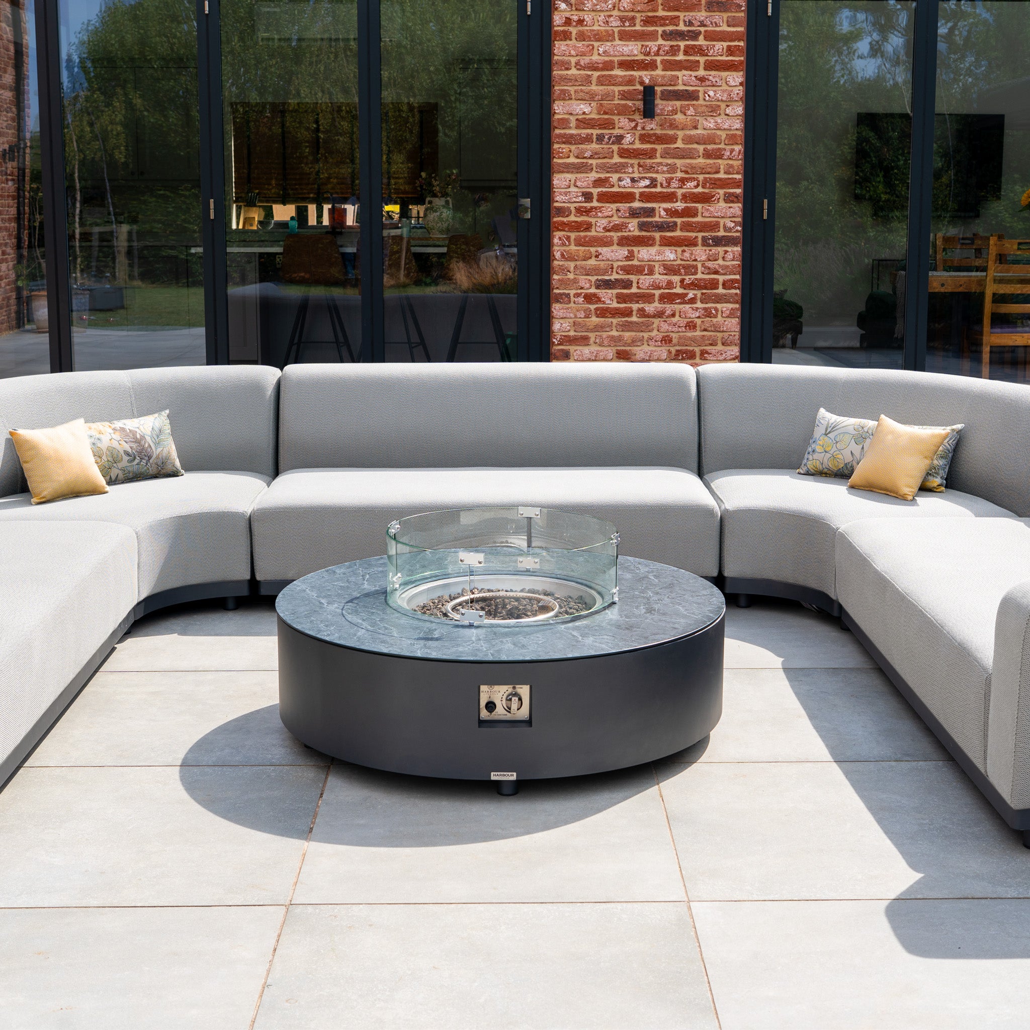 The Luna U-Shape Outdoor Fabric Curved Corner Group with Round Firepit Coffee Table in Oyster Grey creates a stylish patio oasis, combining comfort and modern design for your outdoor space. Pillows included.
