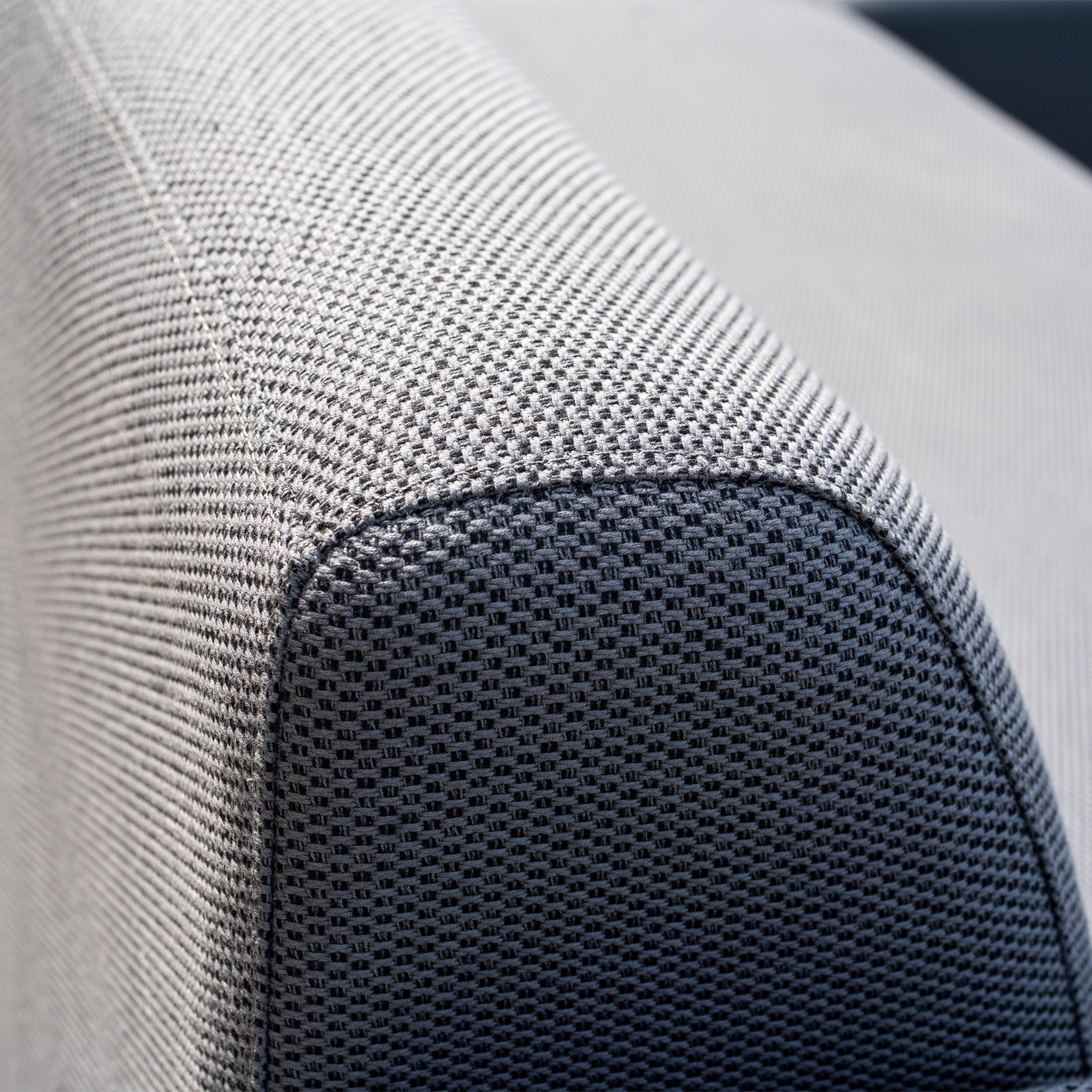 Close-up of the textured fabric on the armrest and backrest of the Luna Outdoor Fabric Curved Corner Sofa Set with Altura Rising Table in Grey, perfect for all-weather garden use.
