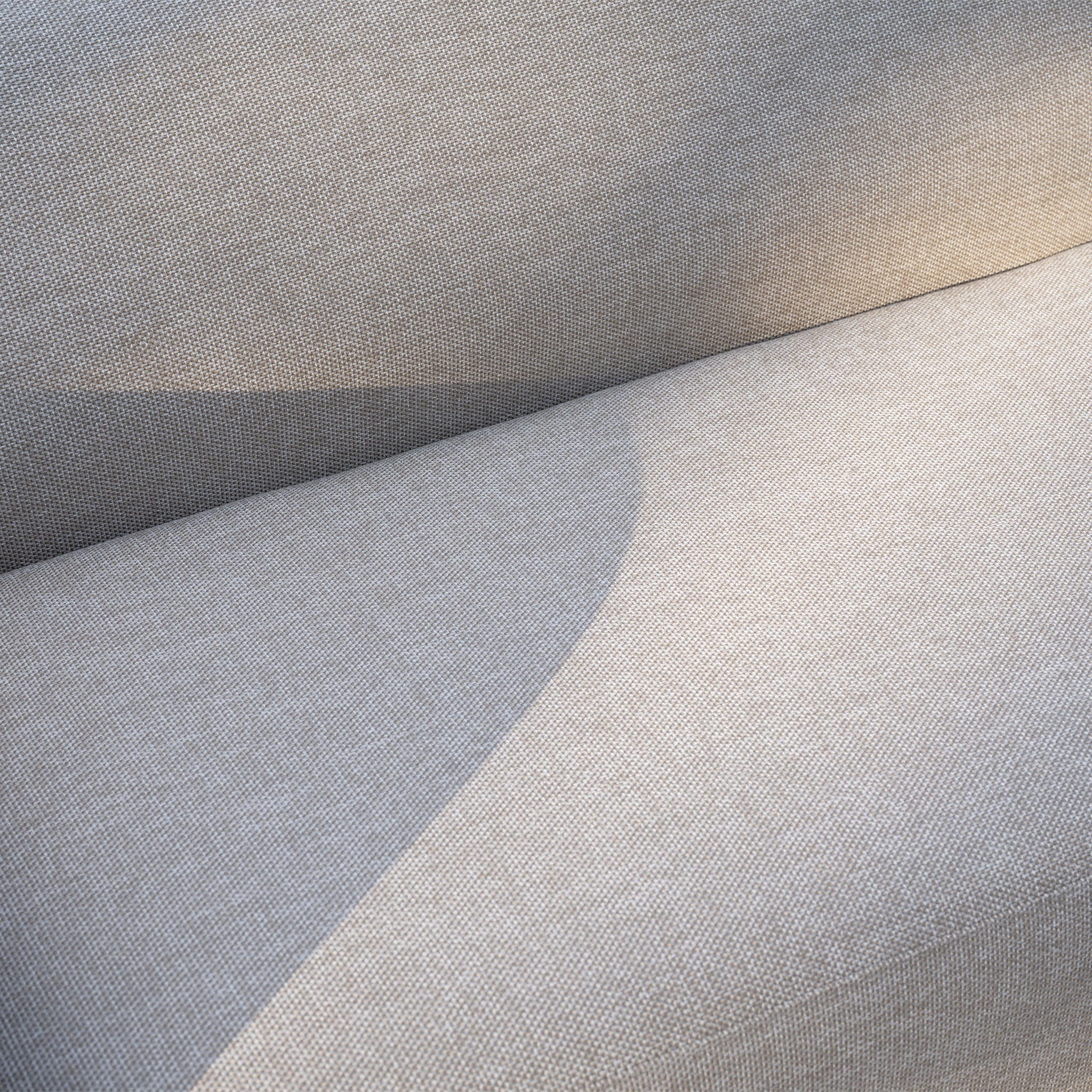 Close-up of the Luna Outdoor Fabric Large Curved Corner Sofa Set with Altura Rising Table in Fawn, showing a light gray finish and quick-dry cushions, highlighting its stylish design and durability for outdoor use.