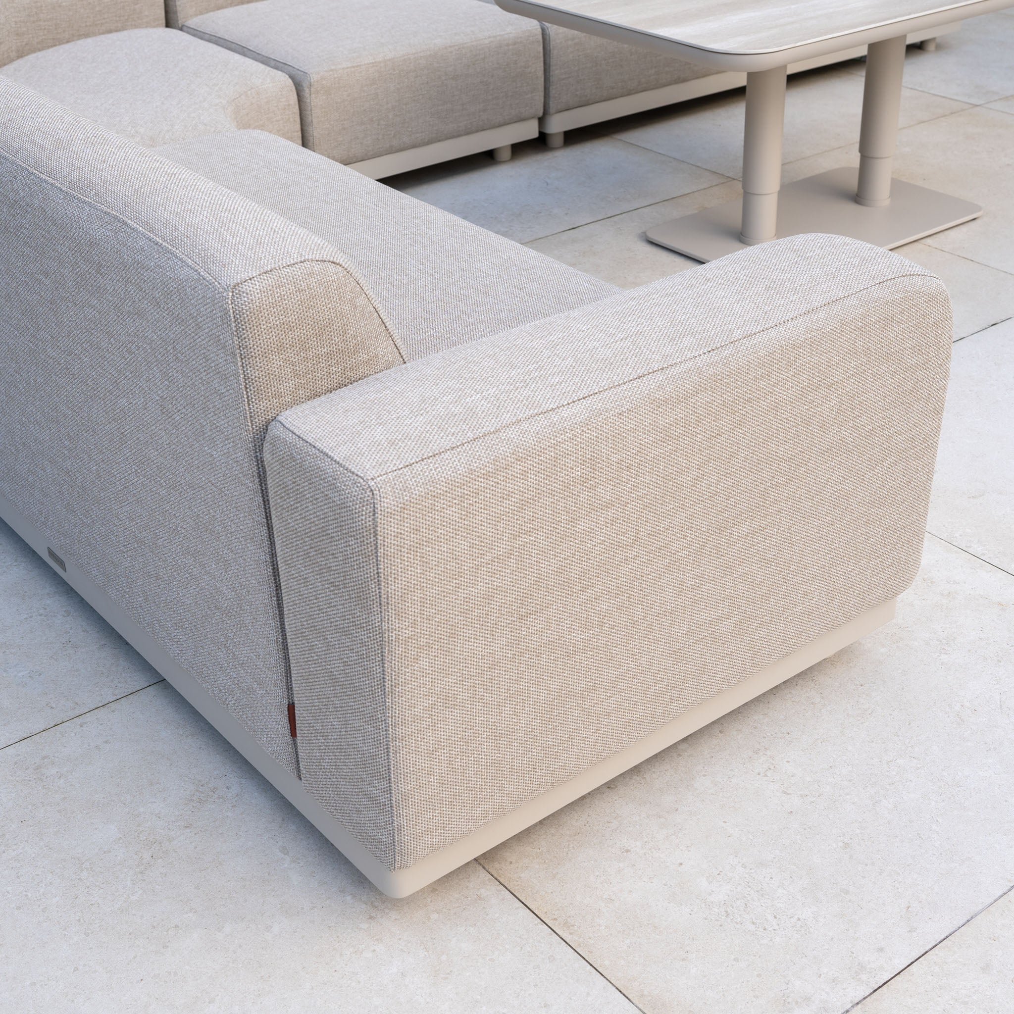 The Luna Outdoor Fabric Large Curved Corner Sofa Set with Altura Rising Table in Fawn features quick-dry cushions and all-weather comfort—ideal garden furniture for relaxed outdoor living on your patio.