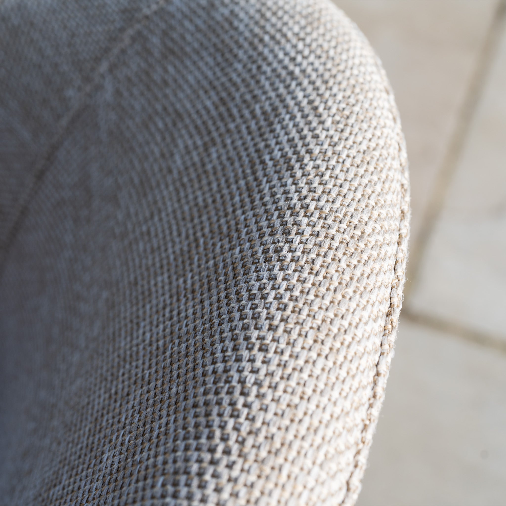 Close-up of the Luna 6 Seat Outdoor Fabric Oval Ceramic Dining Set in Fawn, featuring textured light grey fabric and a rounded backrest.