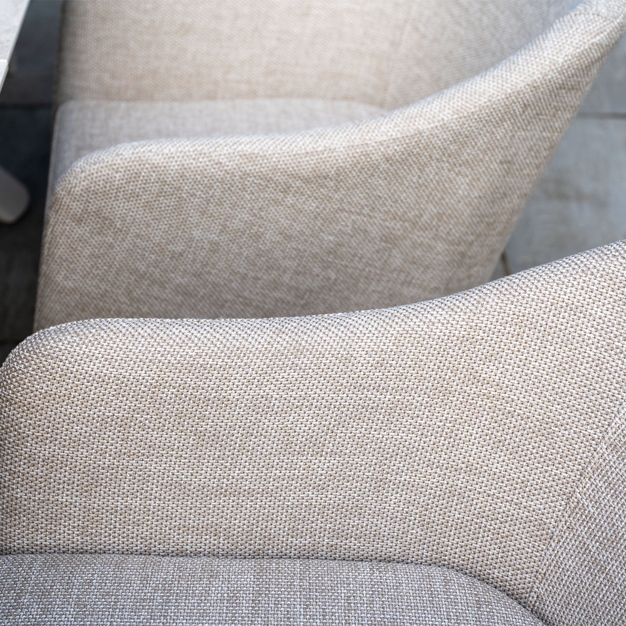 Close-up of the Luna 8 Seat Outdoor Fabric Oval Dining Set with Albatross Extending Table in Fawn, featuring beige UV-resistant cushioned chairs arranged side by side, viewed from above.