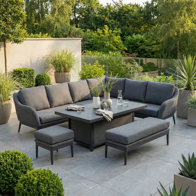 Modern patio featuring the Luna Outdoor Fabric Rectangular Corner Dining Set with Rising Table in Grey (Right Hand)—includes sectional seating, a rising table, and benches—all crafted for all-weather durability and contemporary style.