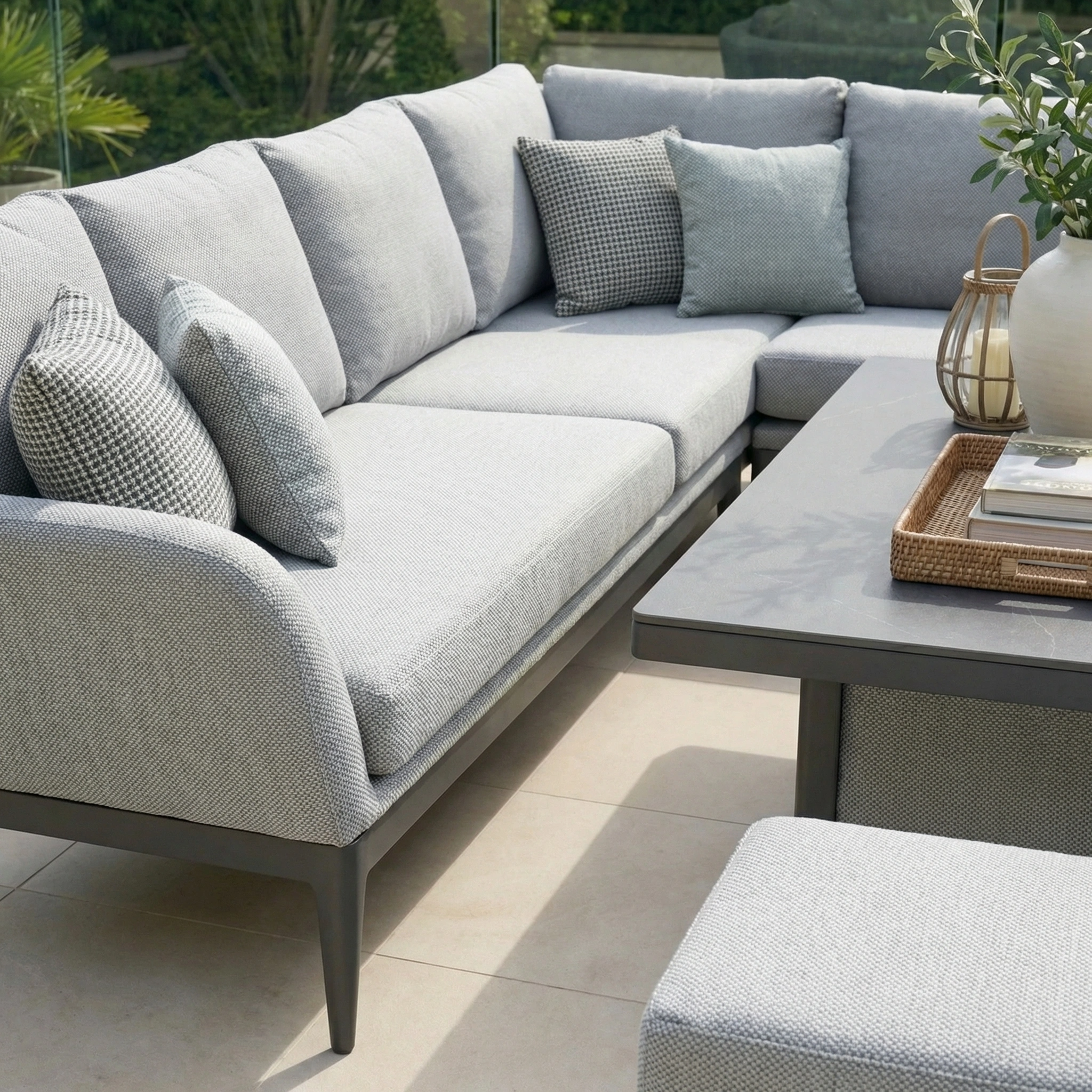 The Luna Outdoor Fabric Rectangular Corner Dining Set with Rising Table in Oyster Grey (Right Hand) features a sectional sofa with cushions and a versatile rising table, perfect for sunny patio dining.