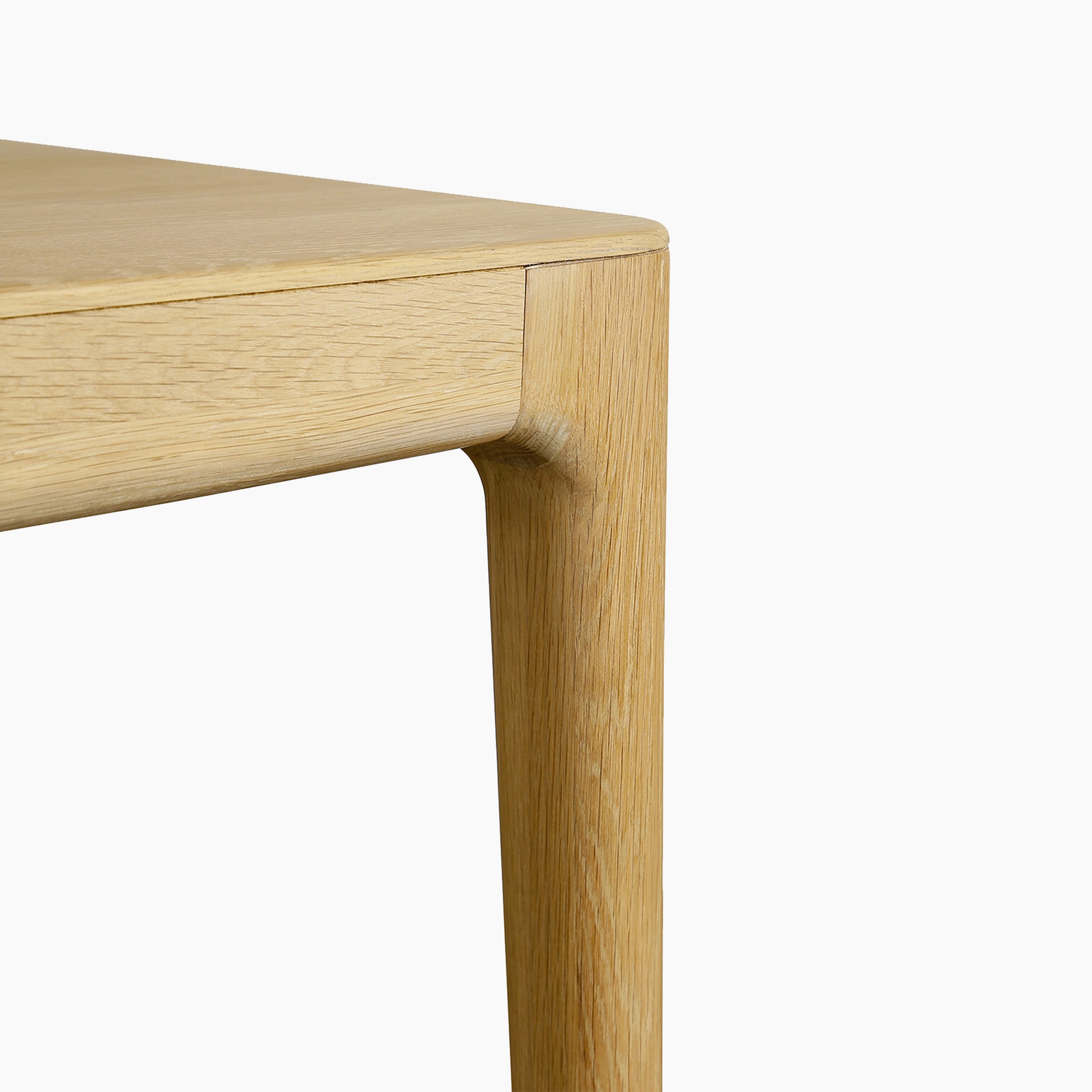 Close-up of the corner and leg of a solid light oak table with smooth, minimalist design—part of the Marlow 8 Seat Dining Set with Wooden Benches in Light Oak.