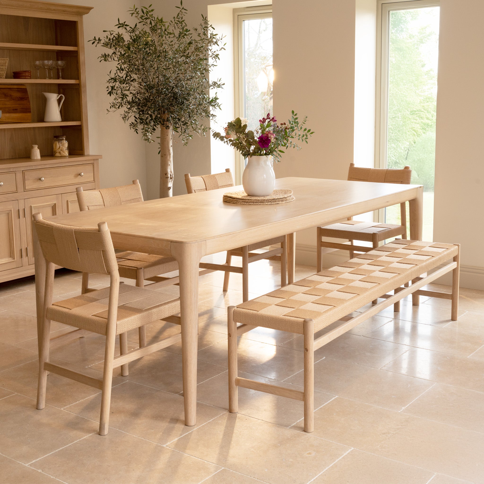 The Marlow 8 Seat Dining Set with Woven Bench in Light Oak brings a warm, inviting atmosphere to your dining room.